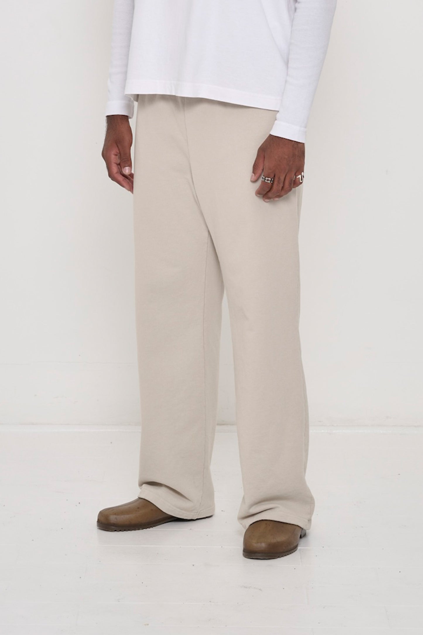 Person facing 45-degrees to the front in Oat Apartment Pants, showing inseam and outseam.