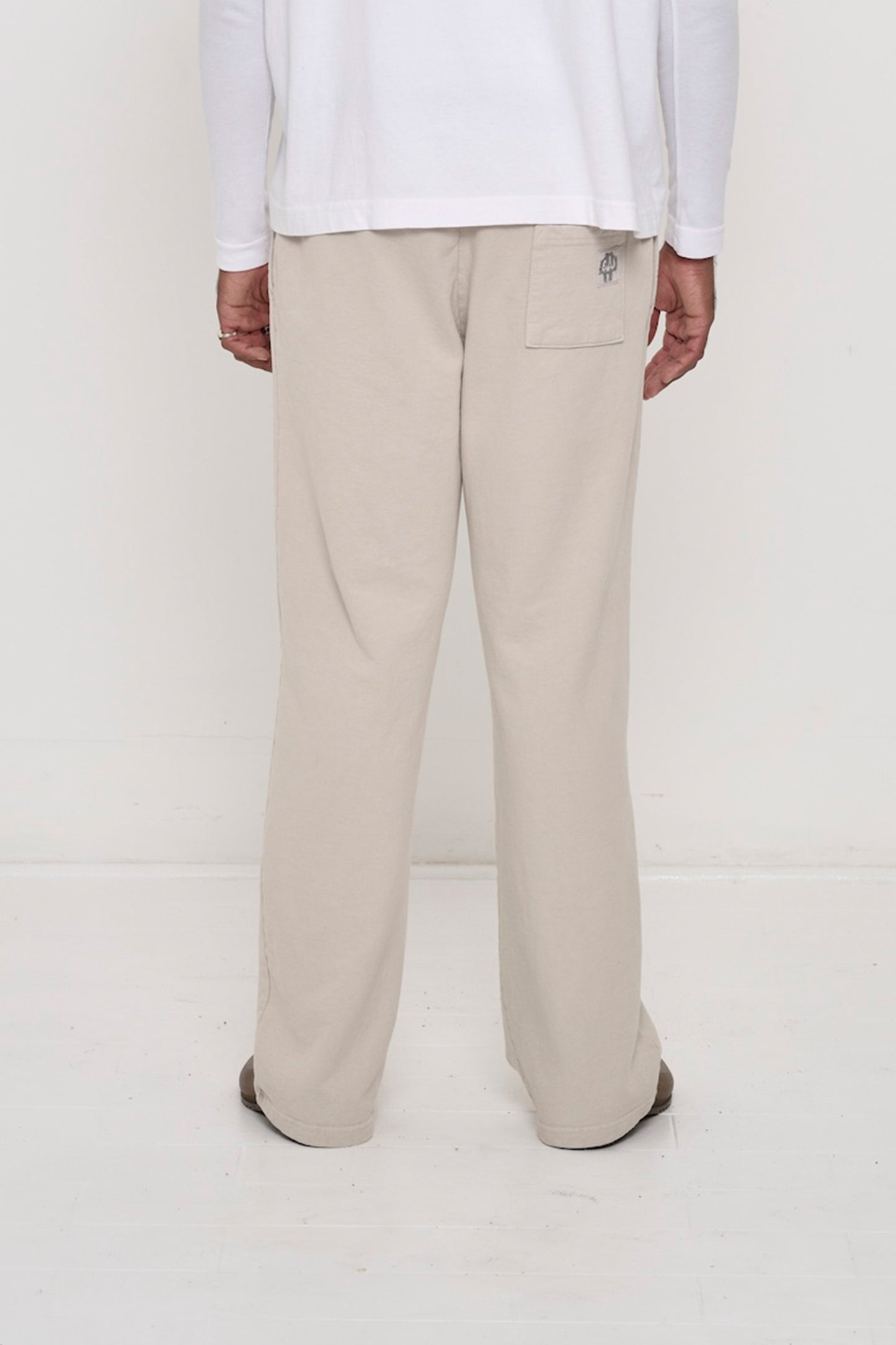 Close-up back view of a person wearing Trash Fleece Apartment Pants in Oat, highlighting the back pocket.