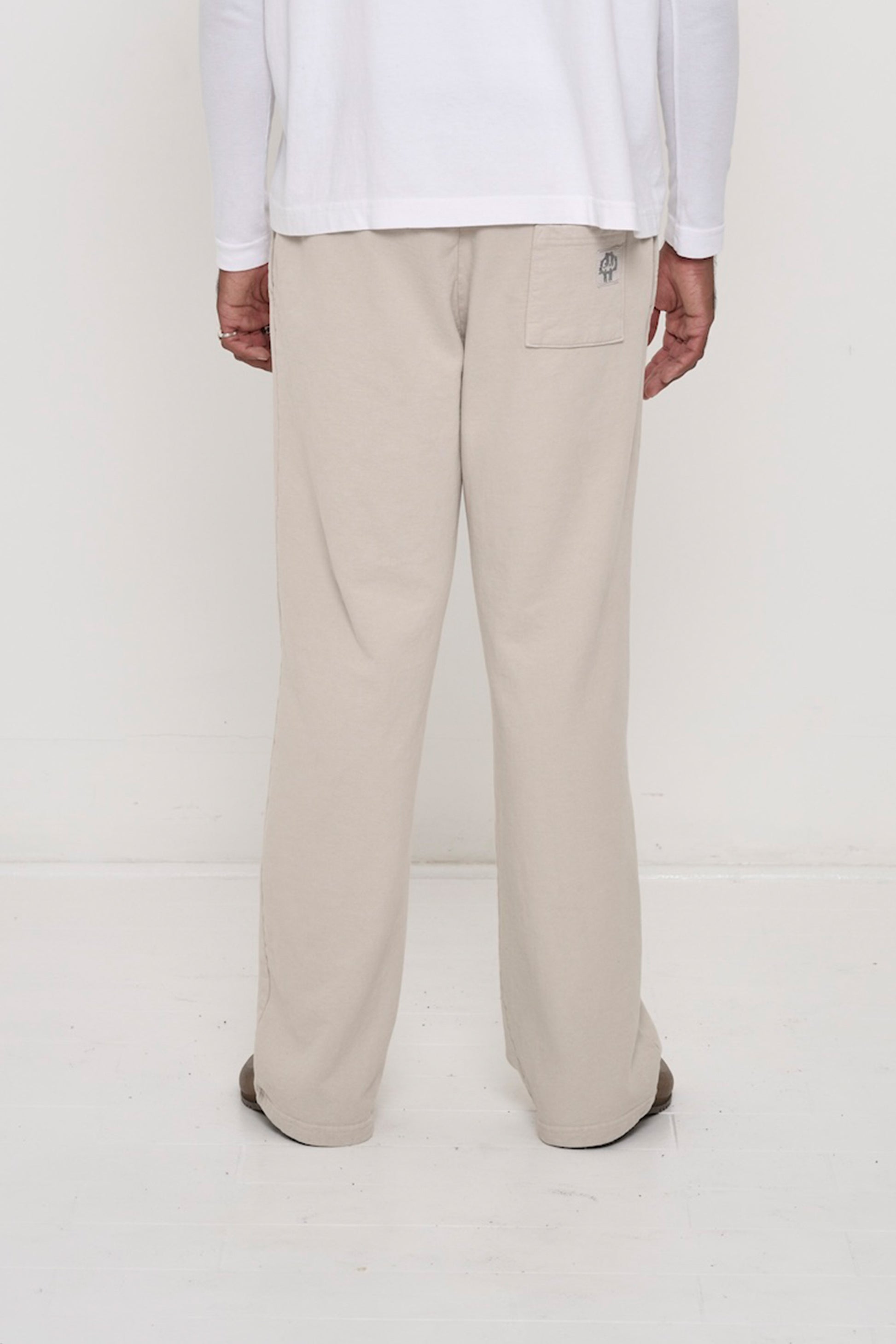 Close-up back view of a person wearing Trash Fleece Apartment Pants in Oat, highlighting the back pocket.