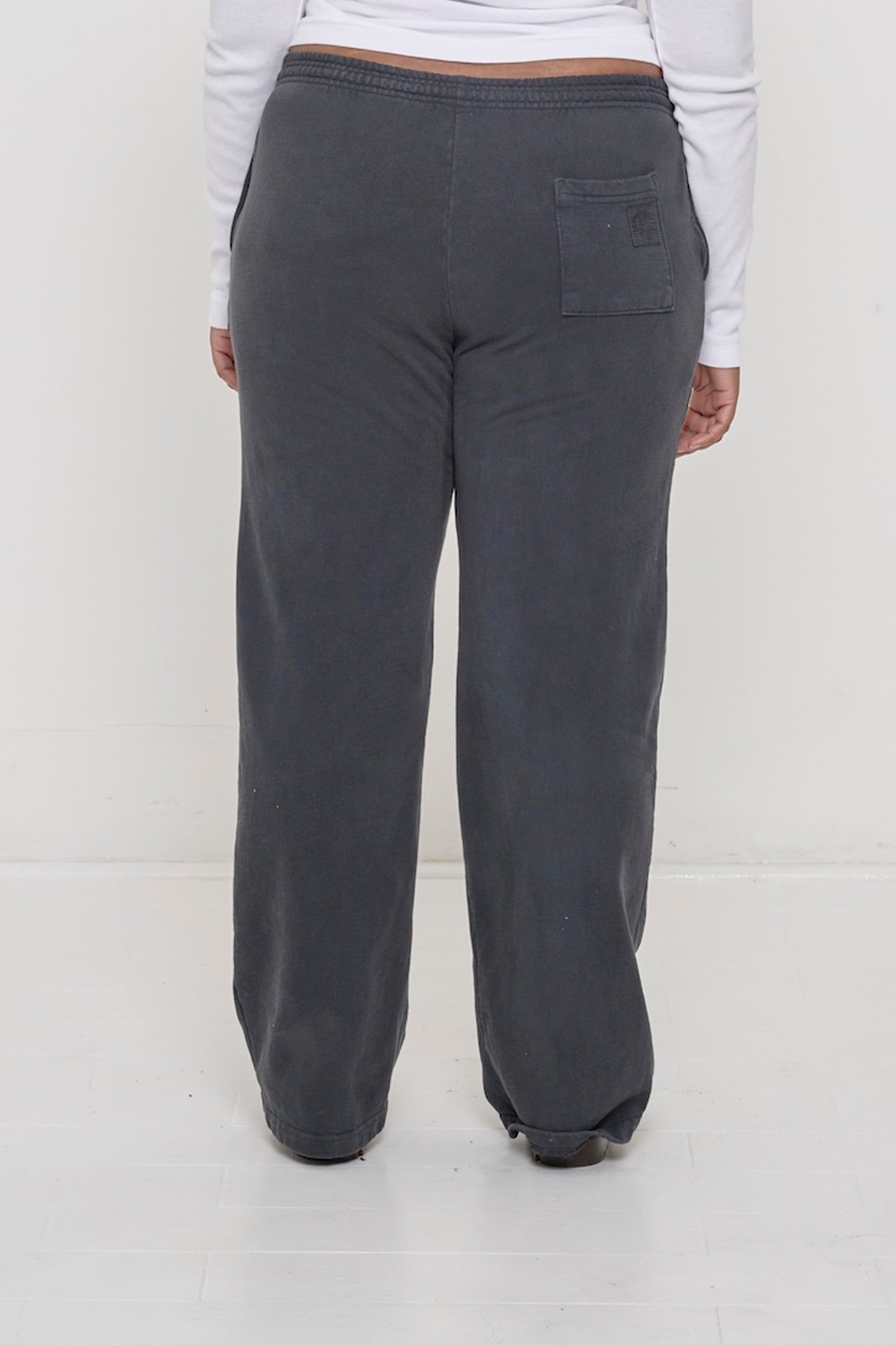 Close-up back view of a person wearing Trash Fleece Apartment Pants in Slate, highlighting the back pocket.