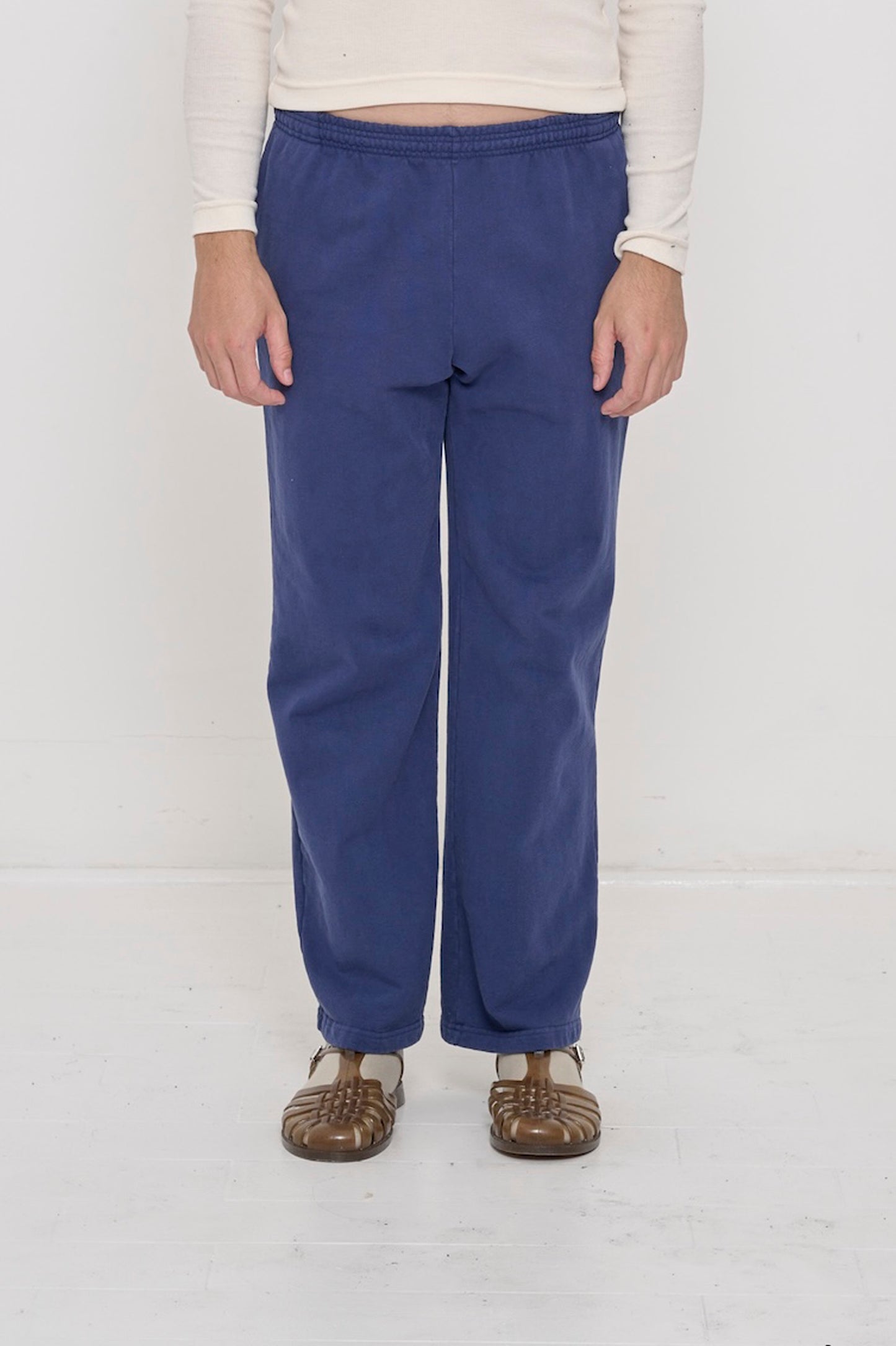 Close-up front view of a person wearing Trash Fleece Apartment Pants in Washed Navy, showing waistband and relaxed drape.