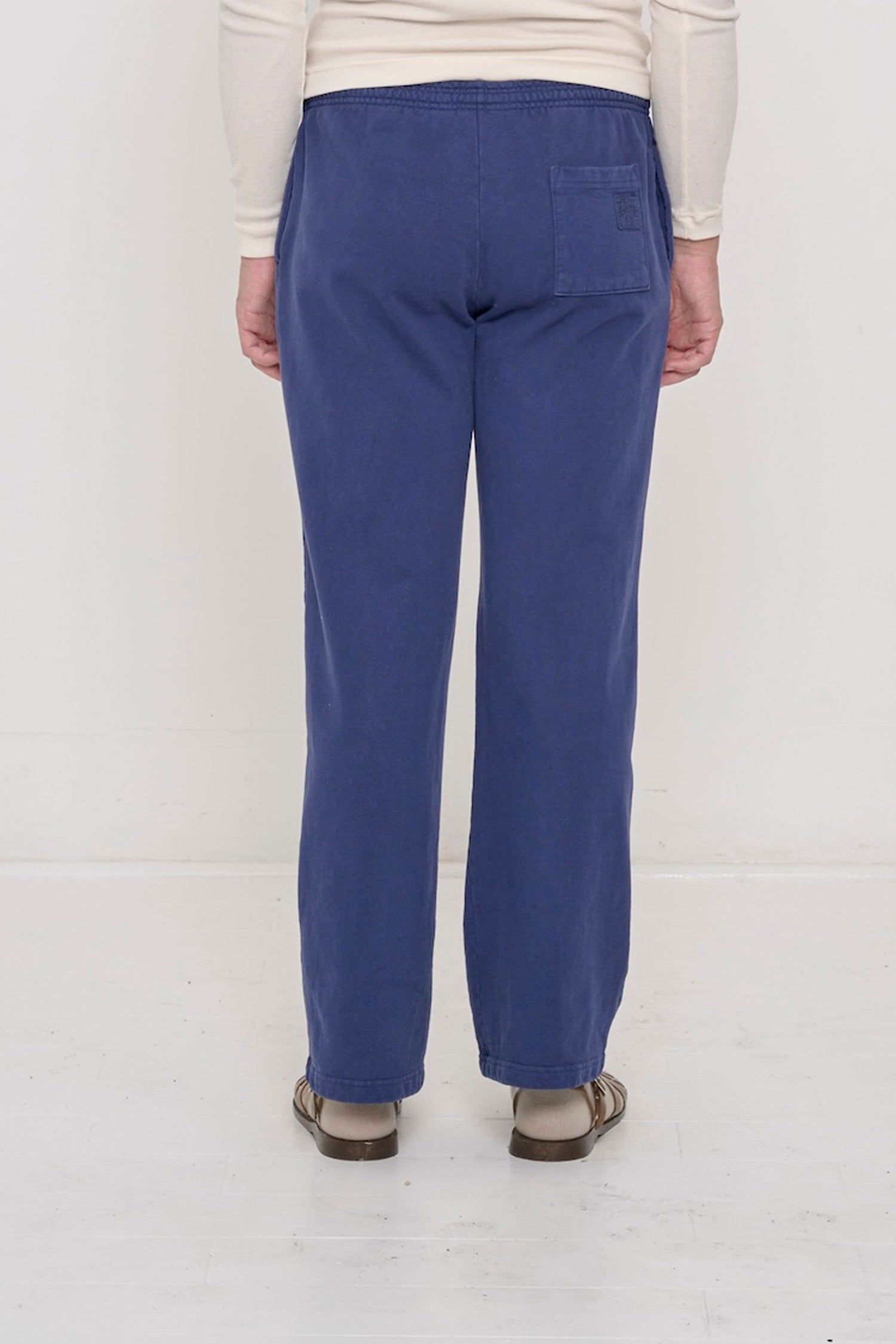 Close-up back view of a person wearing Trash Fleece Apartment Pants in Washed Navy, highlighting the back pocket.