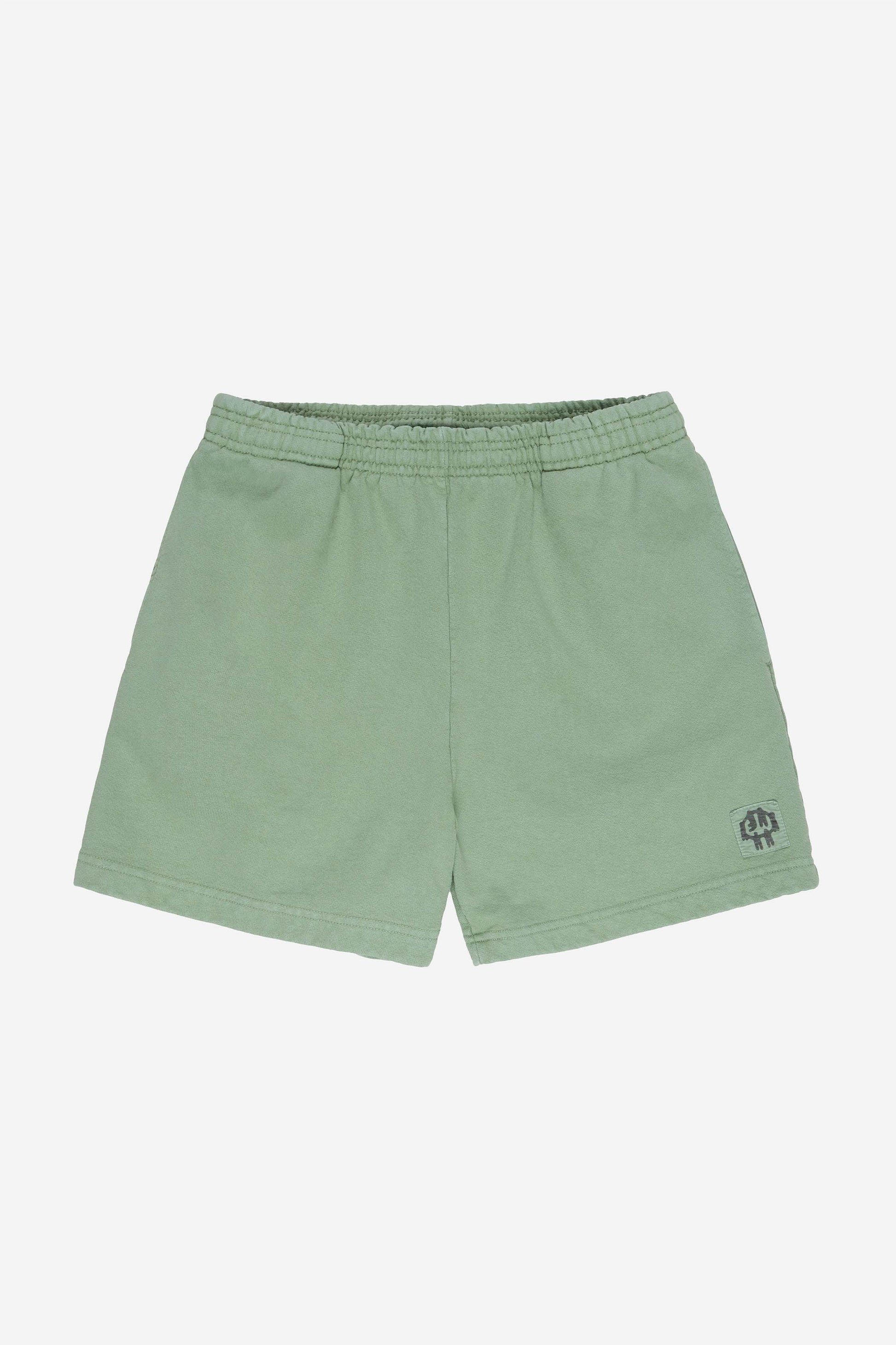 Flat lay of Wasabi Trash Fleece Everyday Shorts shows elastic waist and E.W patch logo on bottom left shorts leg.