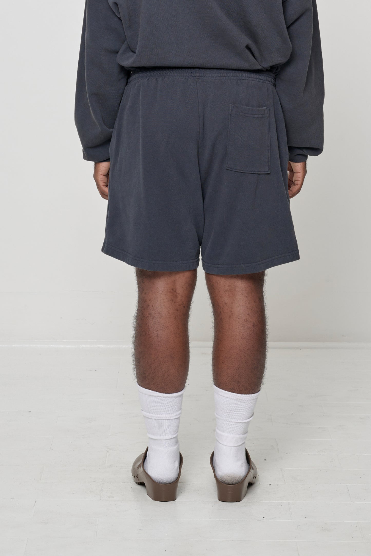Back view of Slate Trash Fleece Everyday Shorts on model, showing back pocket on right side.