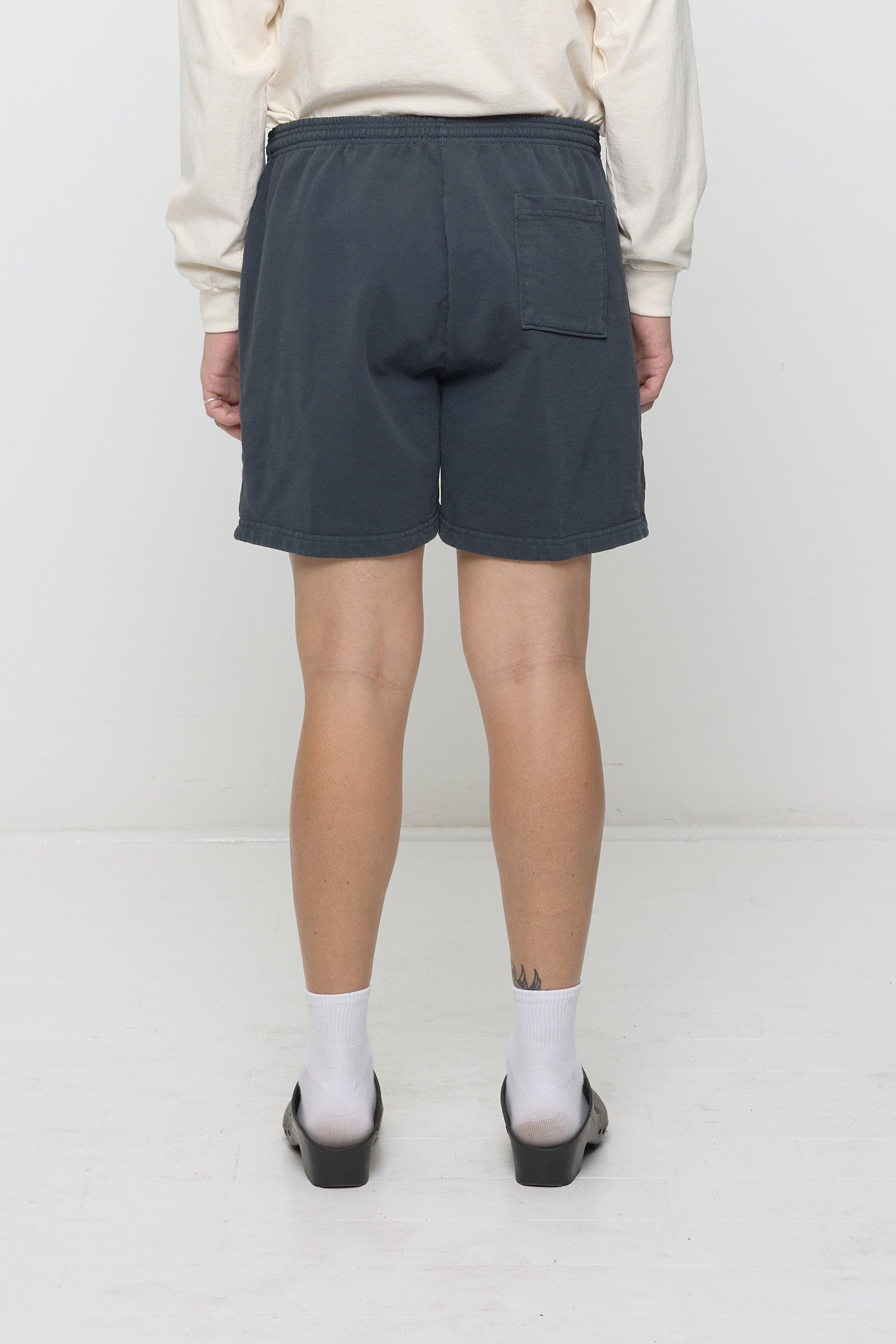 Back view of Slate Trash Fleece Everyday Shorts on model, showing back pocket on right side.