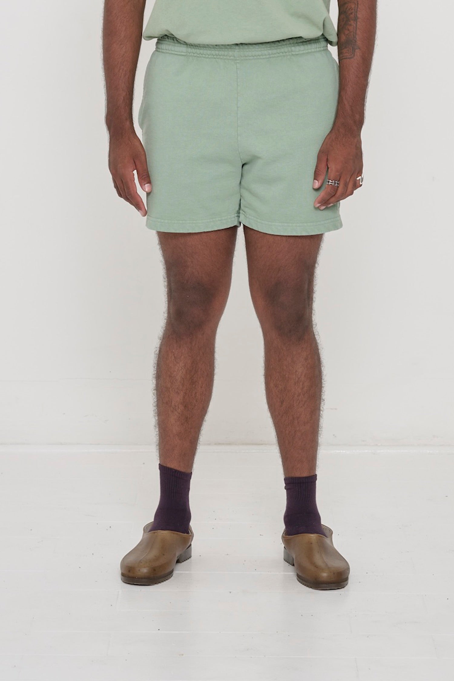 Waist down of a 6'2" person in Size L Wasabi light green Trash Fleece Everyday Shorts. Hem at mid thigh.