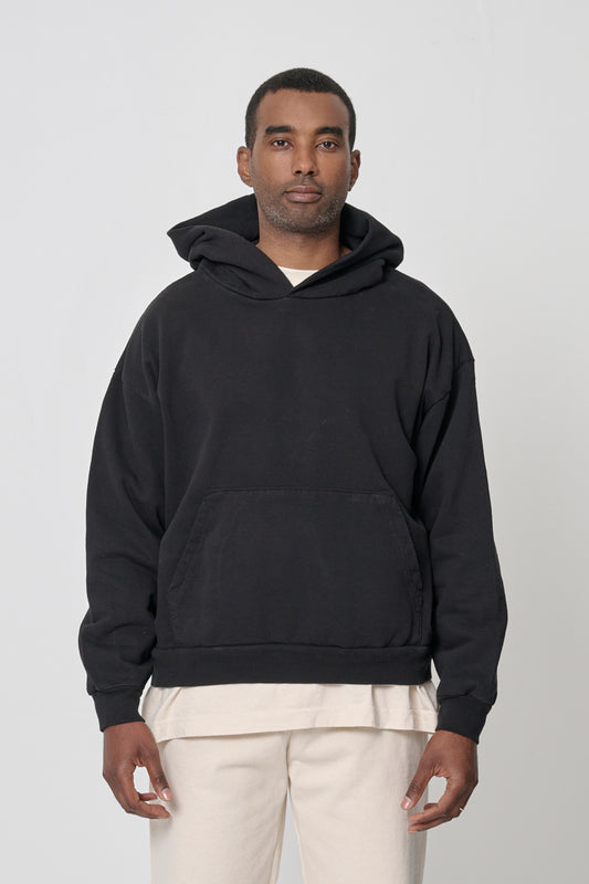 A 6'2" man wearing Black Trash Hoodie in size XL. Hem hits his middle hip.