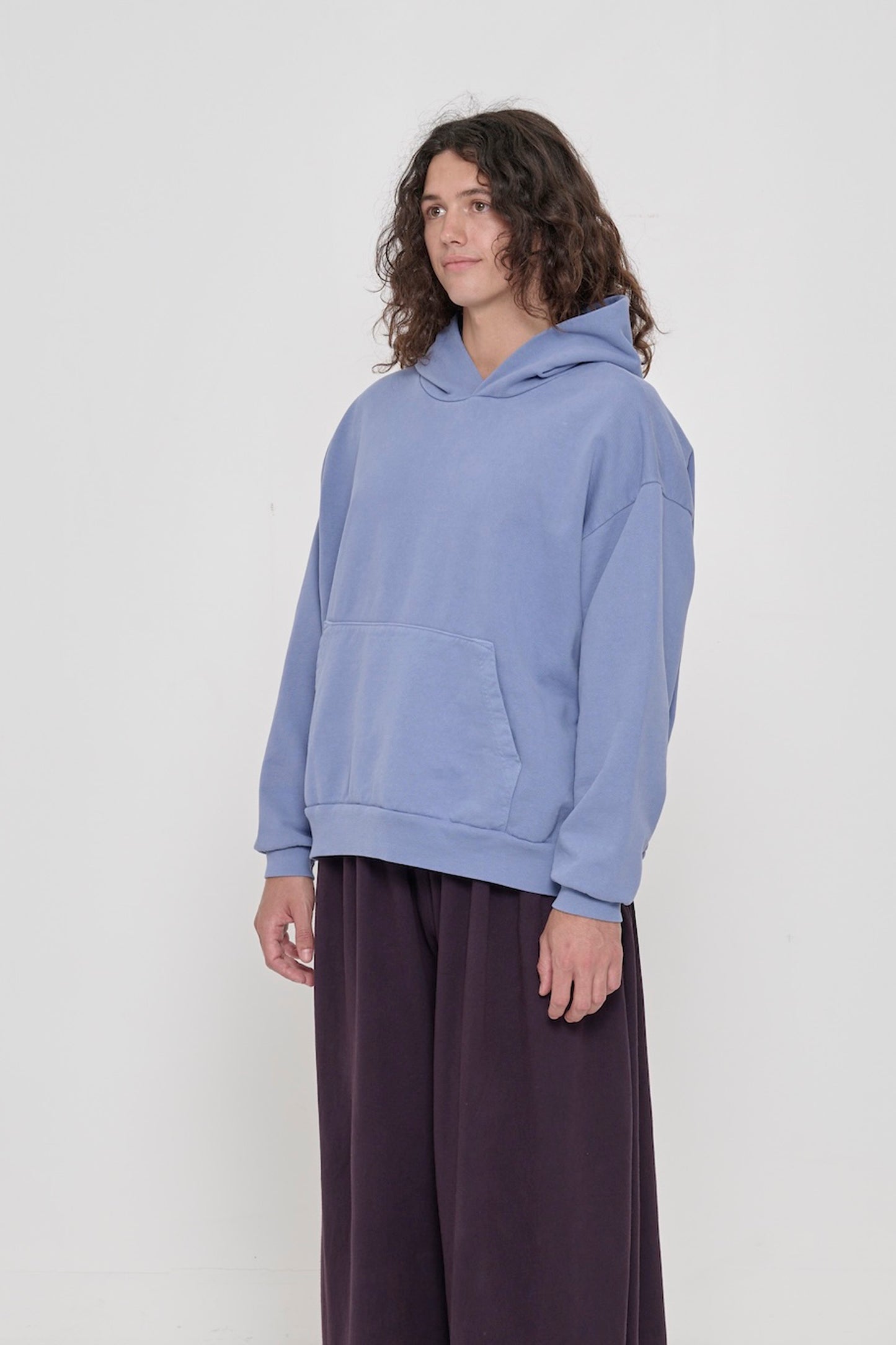3/4 front view of a person wearing a Periwinkle Trash Hoodie, showcasing sleeve's relaxed fit and drop shoulder.
