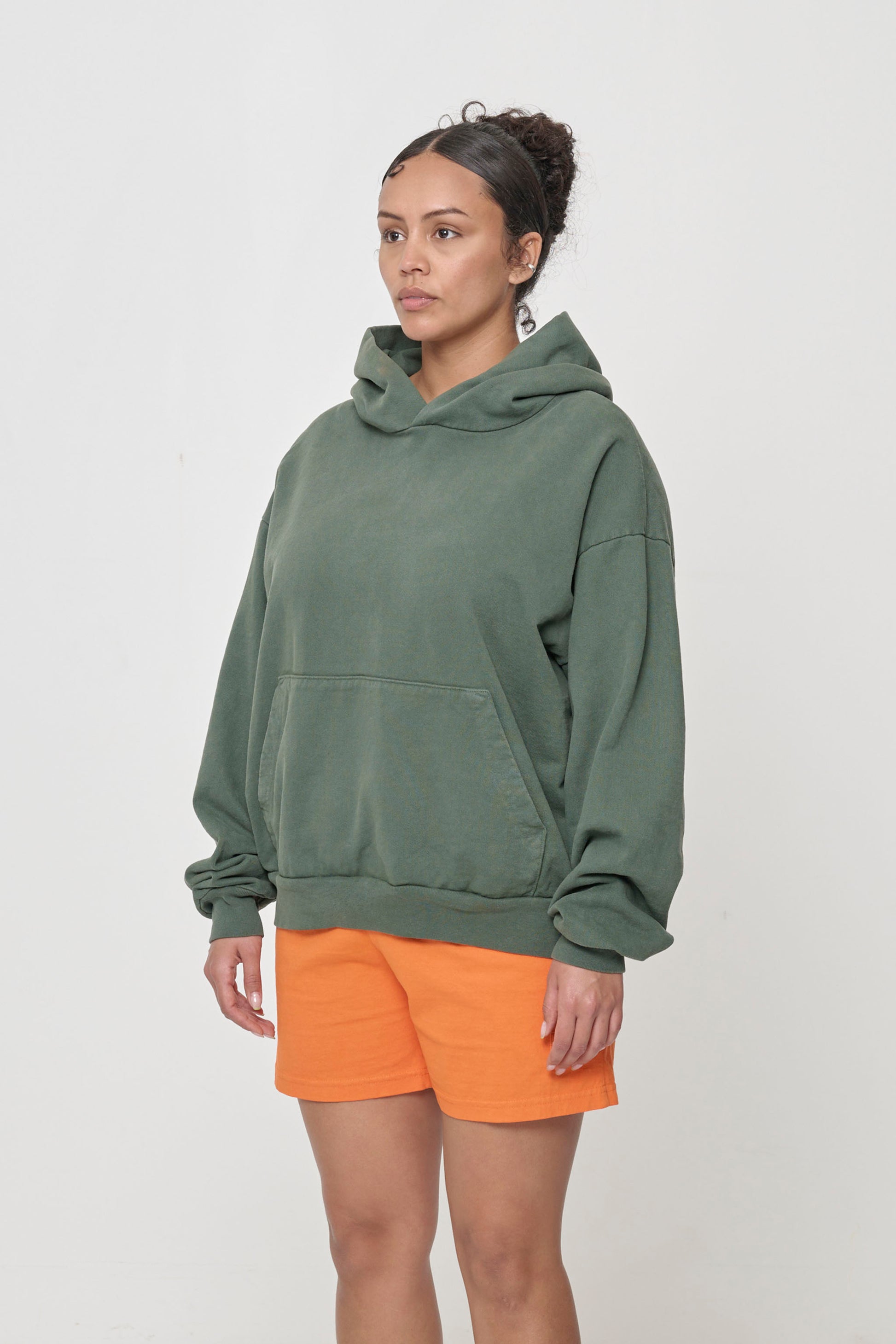 3/4 front view of a woman wearing a Pine Trash Hoodie, showcasing sleeve's relaxed fit and drop shoulder.
