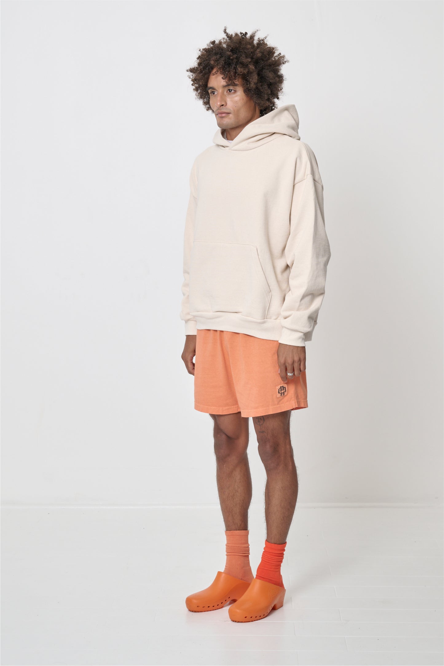 3/4 front view of a man wearing a Scour Trash Hoodie, showcasing sleeve's relaxed fit and drop shoulder.