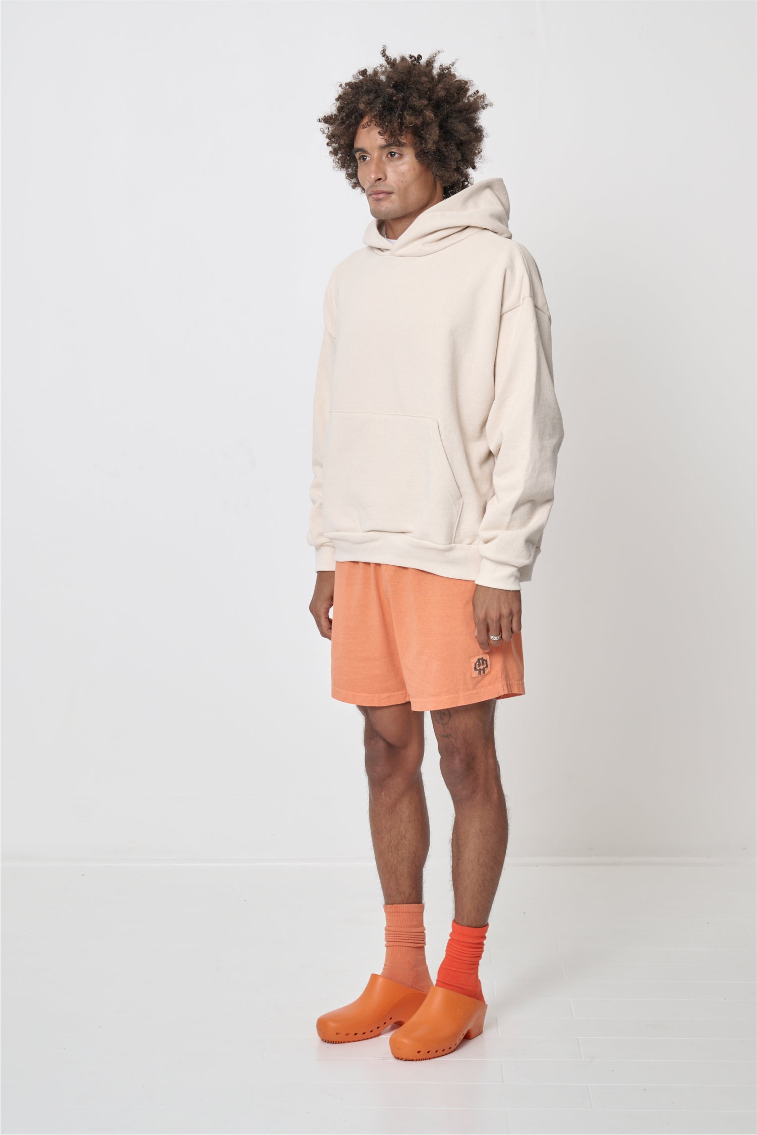 3/4 front view of a man wearing a Scour Trash Hoodie, showcasing sleeve's relaxed fit and drop shoulder.
