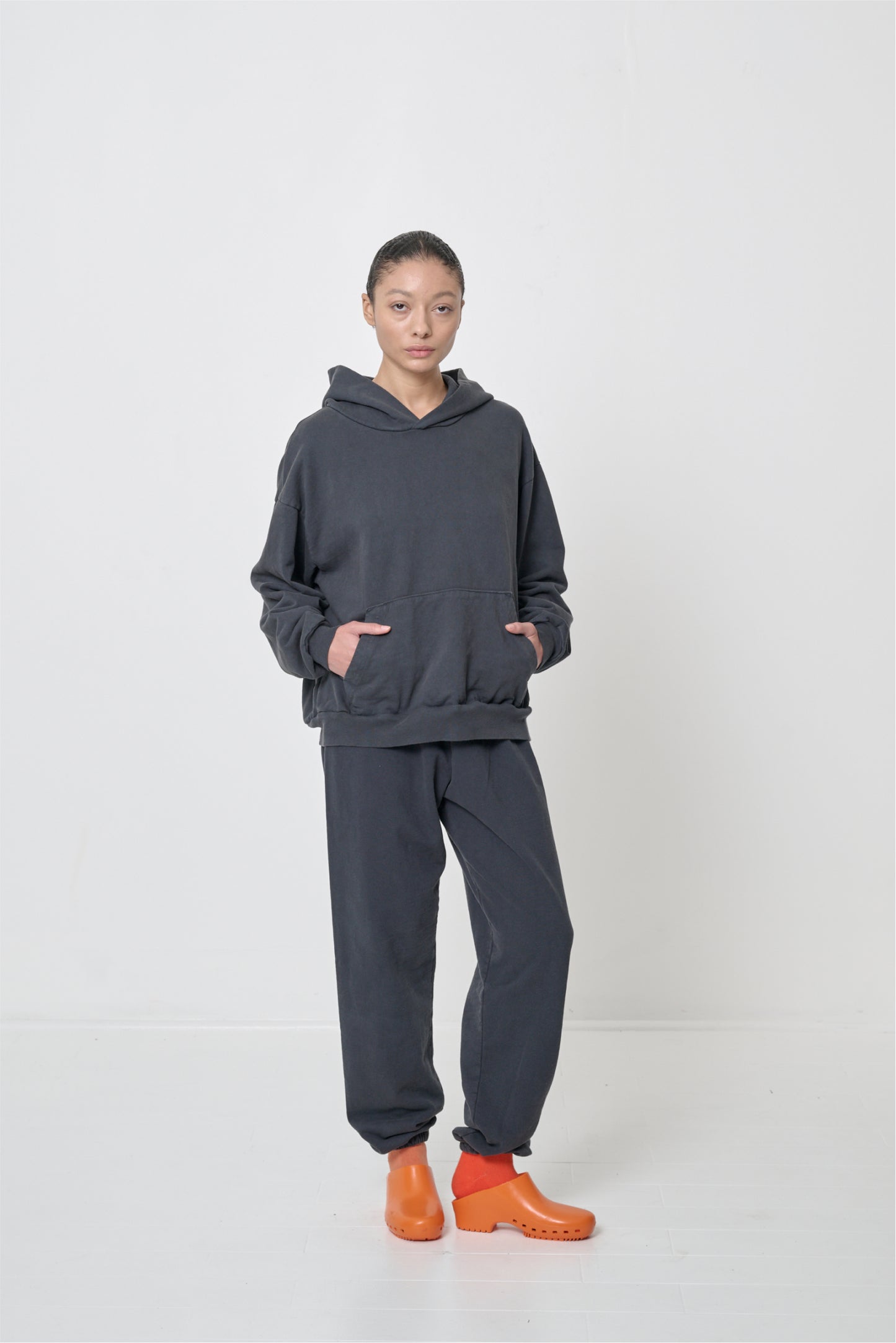 Front full length: woman wearing a Slate Trash Hoodie with hands in the kangaroo pocket