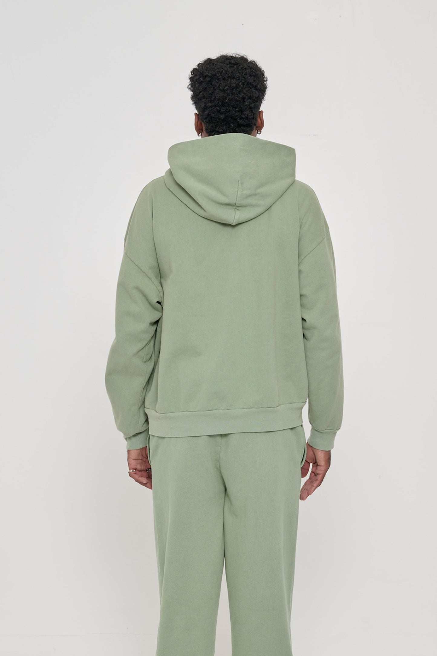 Back view of a man wearing a Wasabi Trash Hoodie, highlighting the hood.