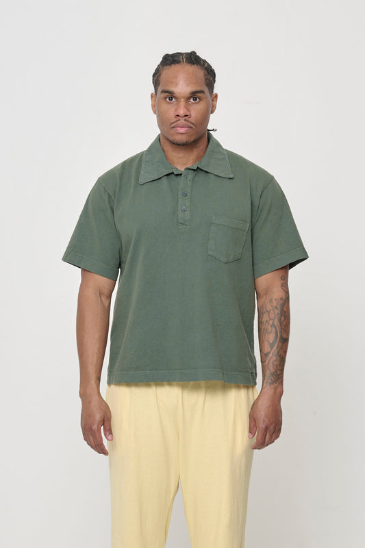 Front view of a 6' man wearing a size L Trash Polo in Pine. Hem hits mid hip.