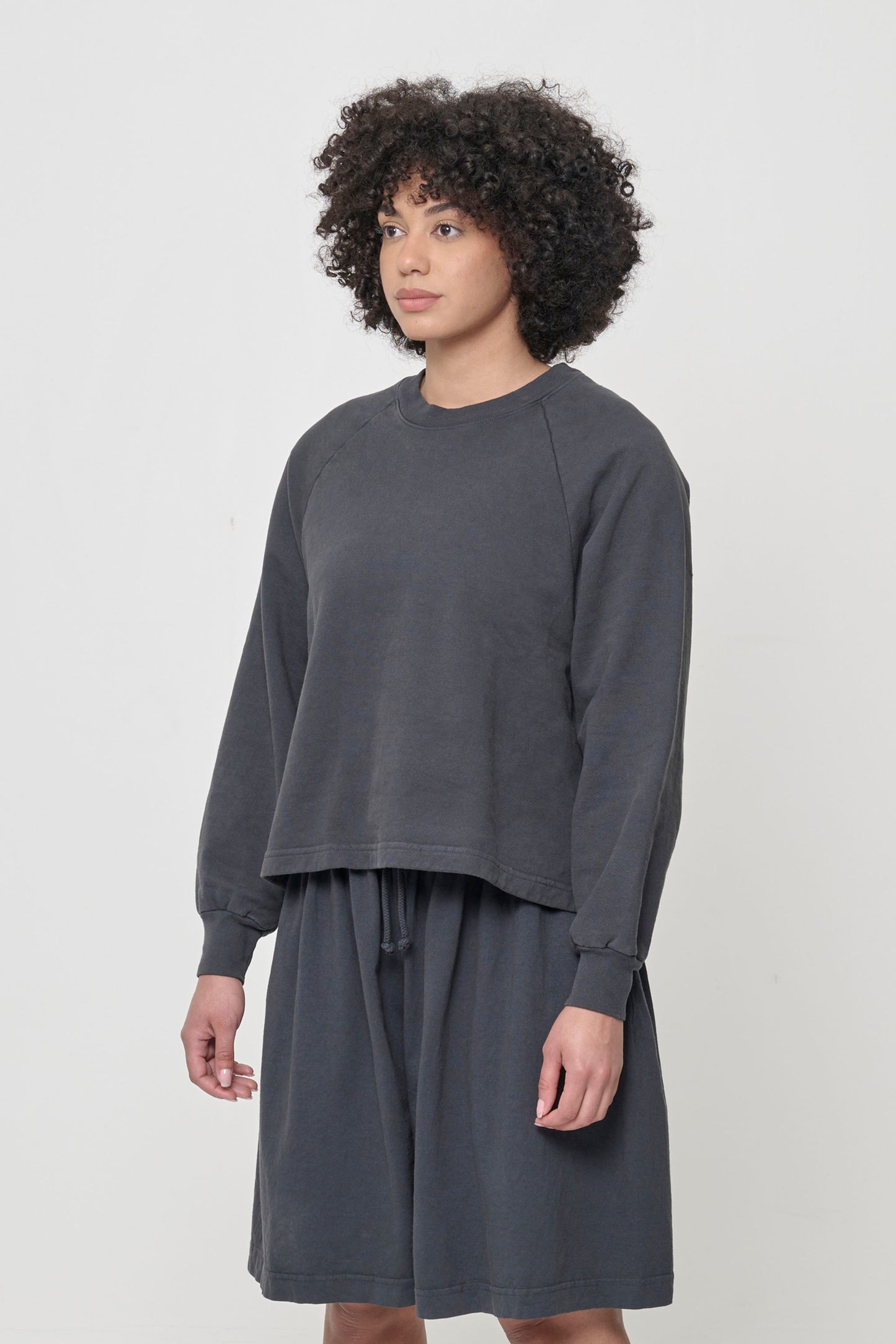 3/4 front view of person wearing a Slate Trash Raglan, showcasing sleeve's relaxed fit.