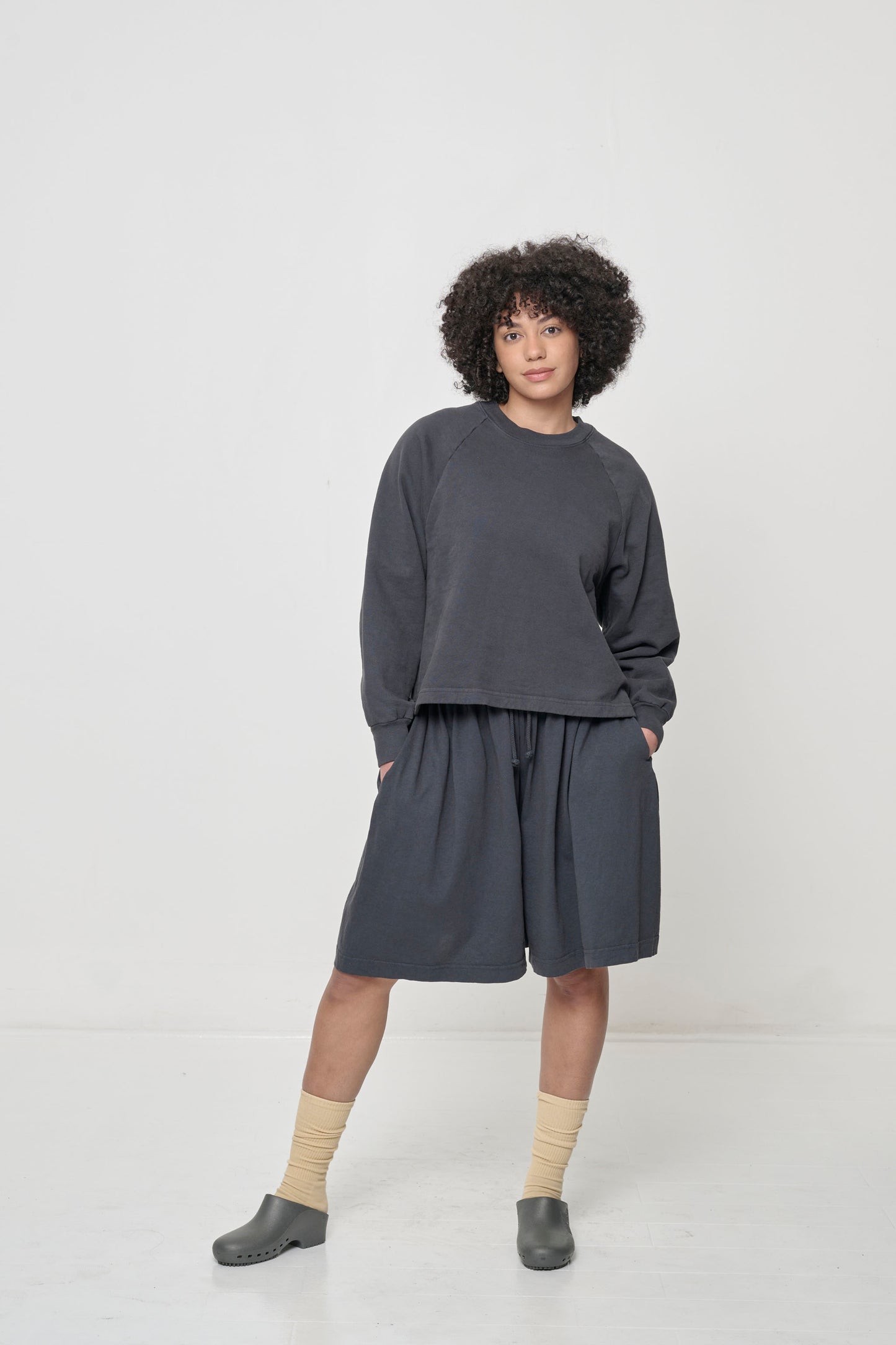 Front full length: woman in a Slate Trash Raglan with hands in Long Tubular Pants pockets, showcasing sleeve's relaxed shape.