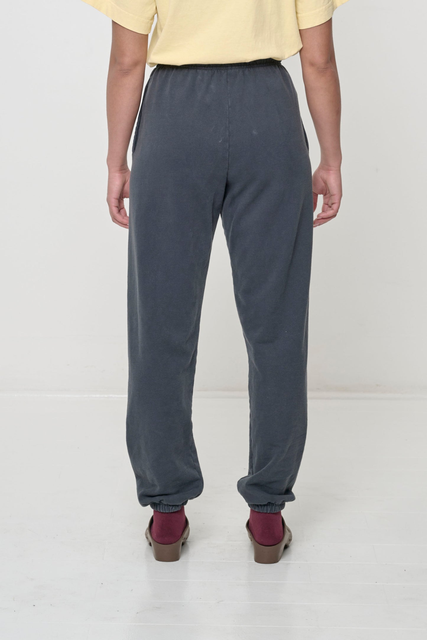 Back view: person wearing Slate Trash Sweatpants, relaxed fit throughout, except for elastic waistband and cuffs.
