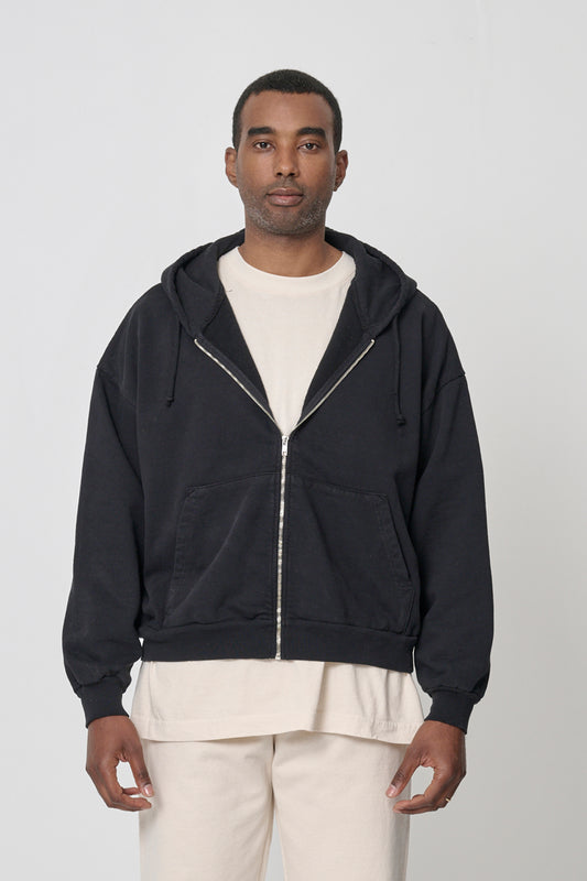 A 6'2" person wearing Black Trash Zip Up Hoodie in size XL. Hem hits mid hip.