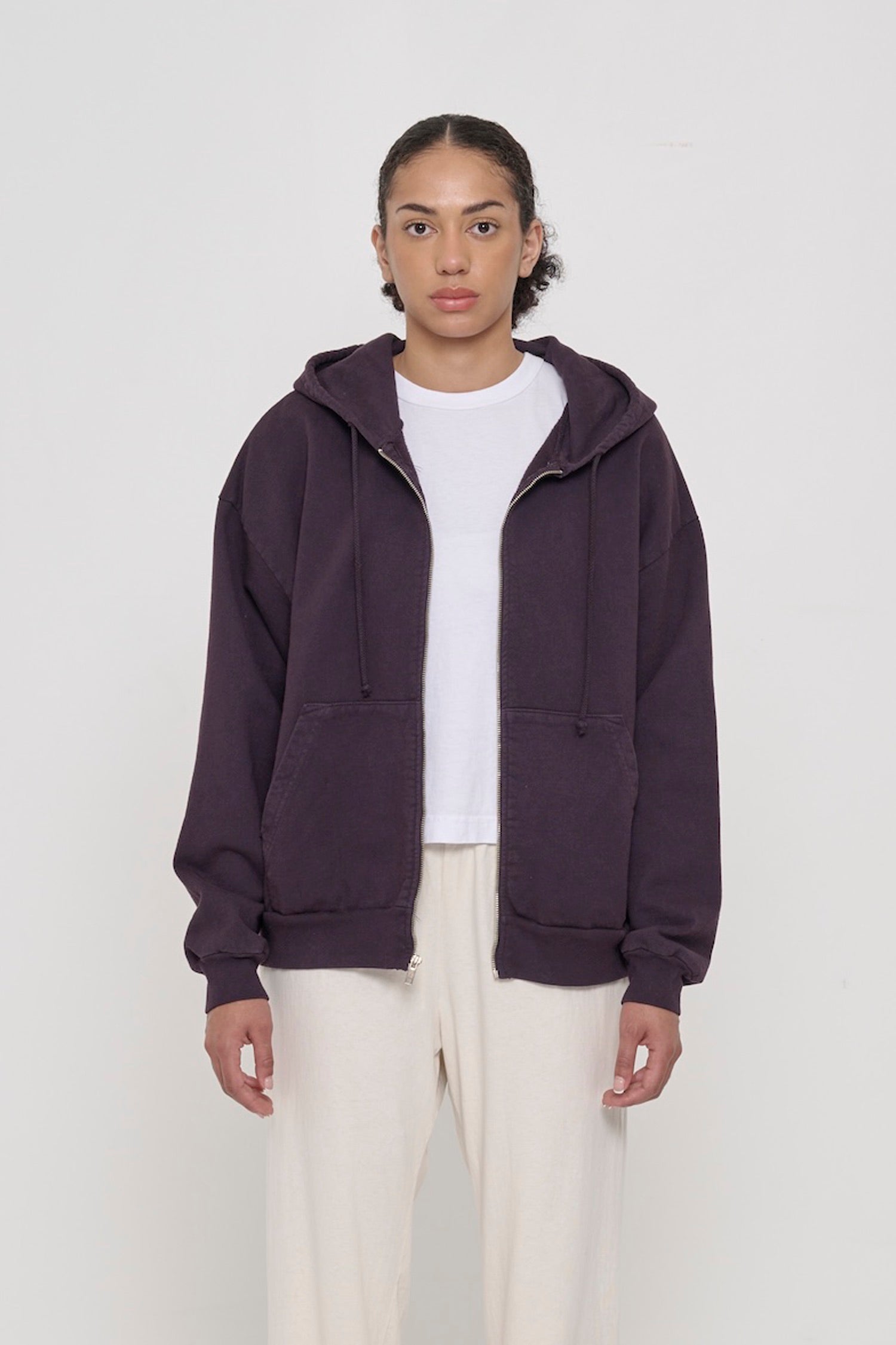 Front view of a person wearing Mulberry Trash Zip Up Hoodie. Hem hits mid hip.