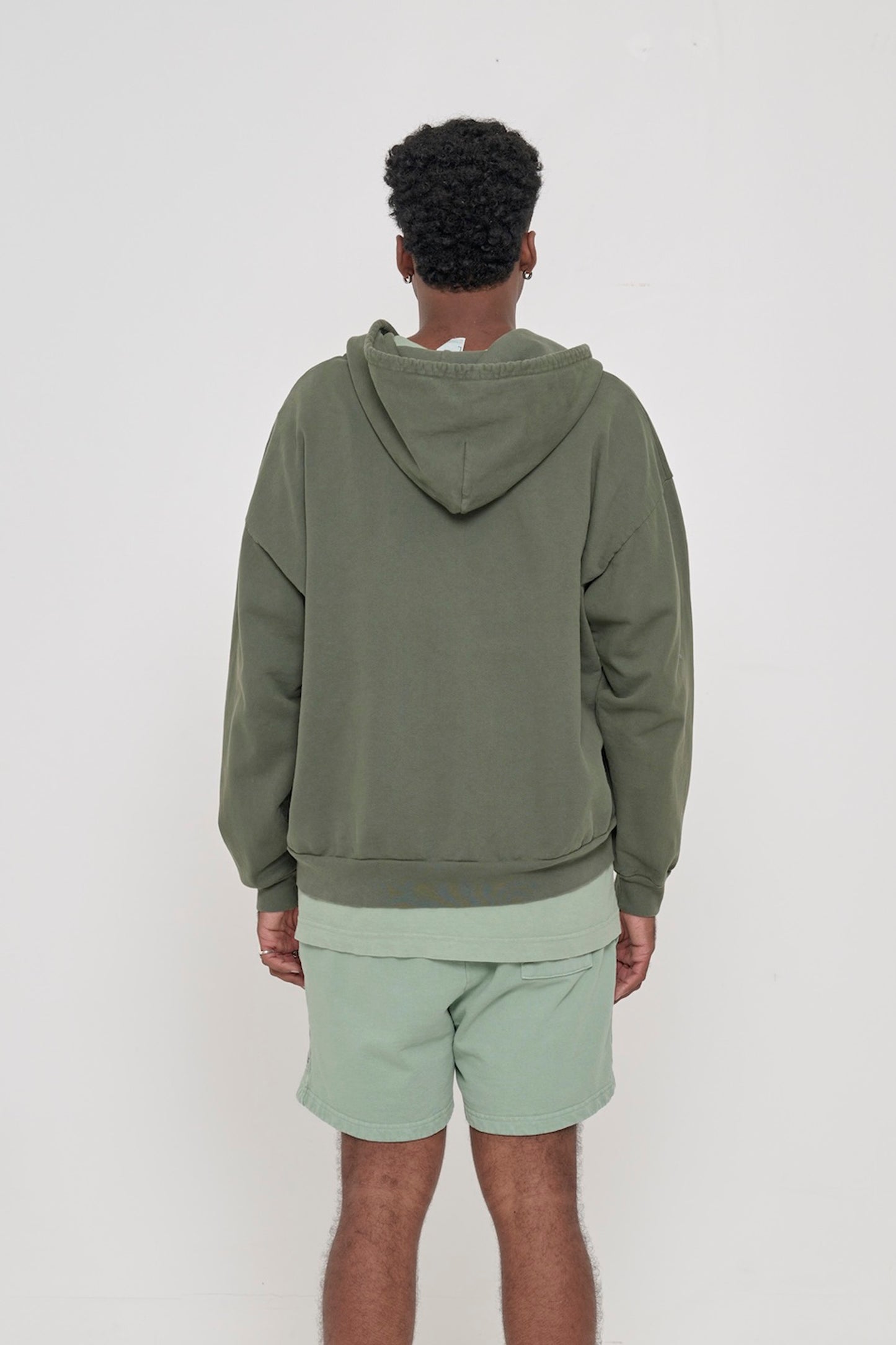 Back view of a person wearing a Pine Trash Zip Up Hoodie, highlighting the hood.