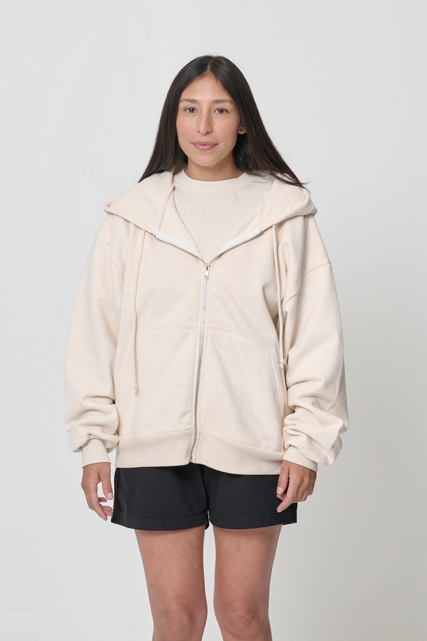 Front view: 5'4" woman wearing Scour Trash Zip Up Hoodie in size S. Hem hits her lower hip.