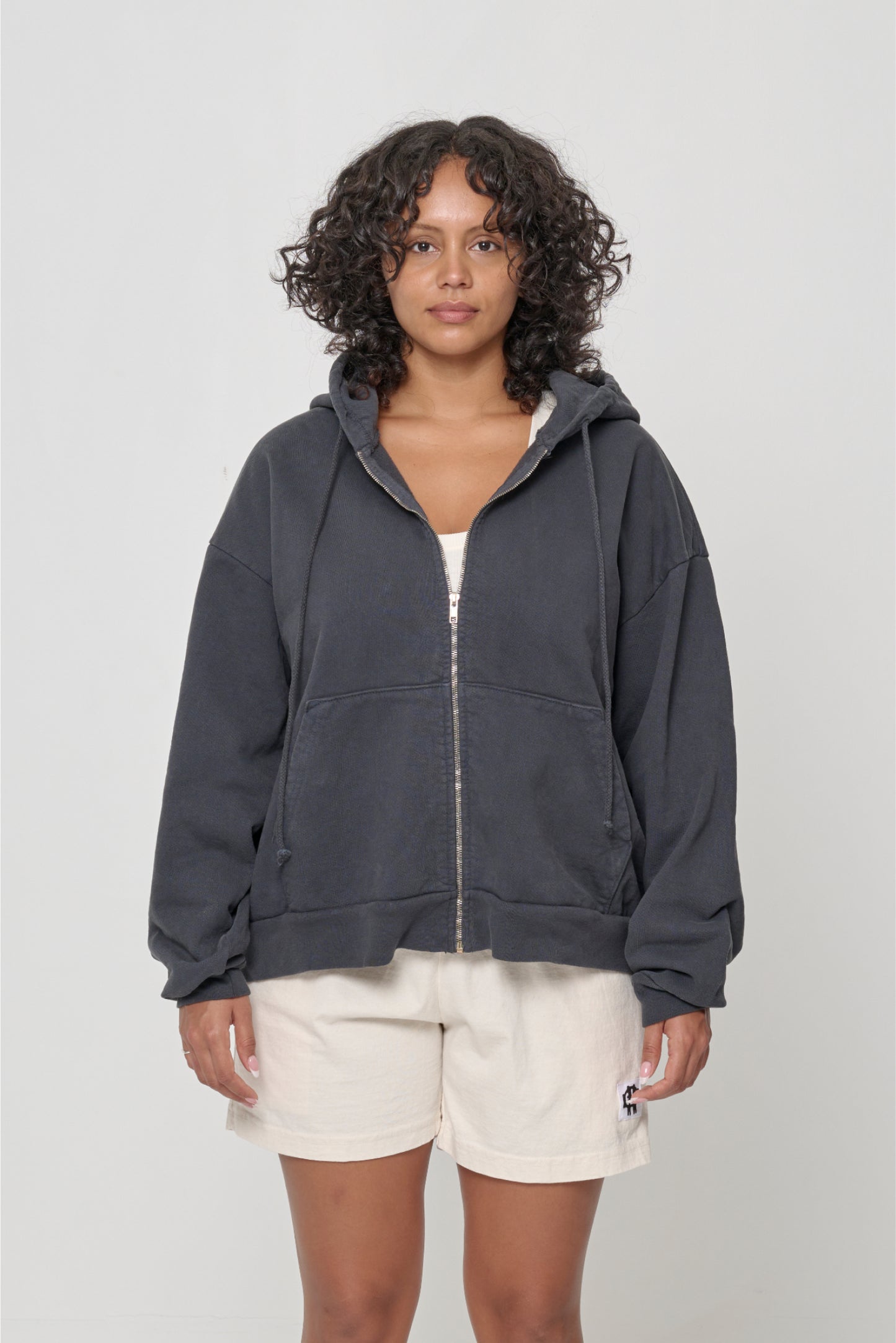 Front view: 5'7" woman wearing Slate Trash Zip Up Hoodie in size M. Hem hits lower mid hip.