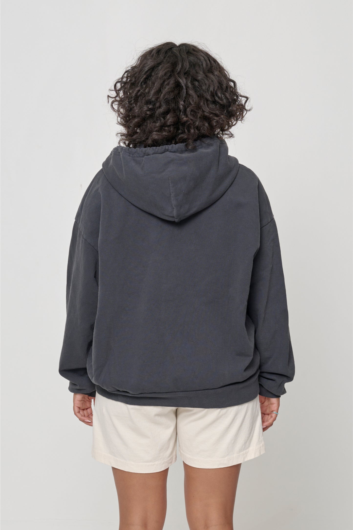 Back view: Woman wearing a Slate Trash Zip Up Hoodie, highlighting the hood.