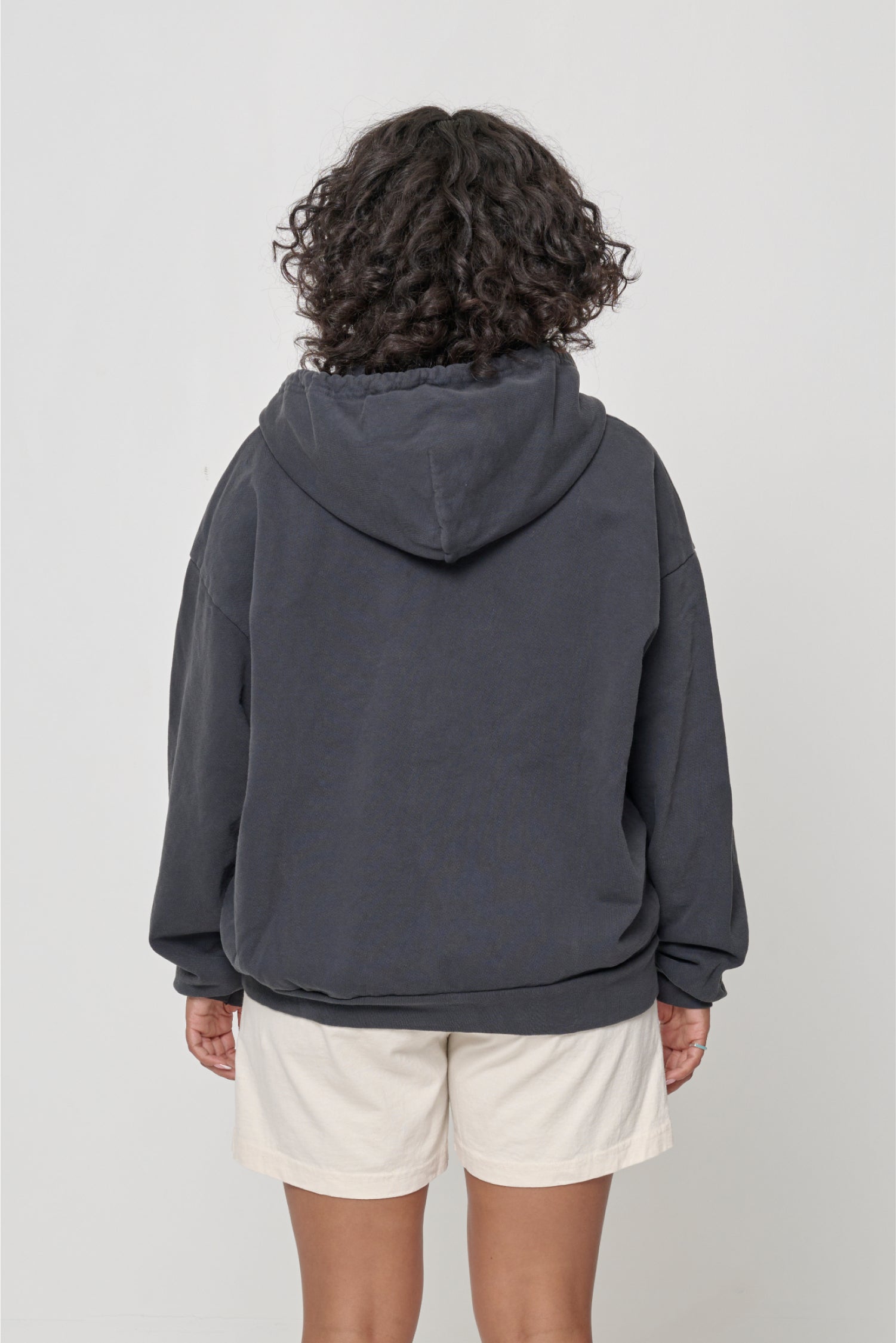 Back view: Woman wearing a Slate Trash Zip Up Hoodie, highlighting the hood.