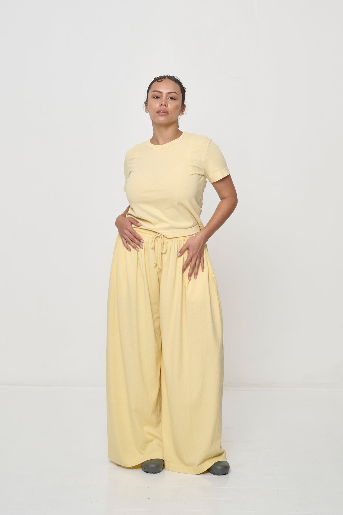 Woman with hip and knee popped, showing the width and movement of the French Butter Tubular Pants.