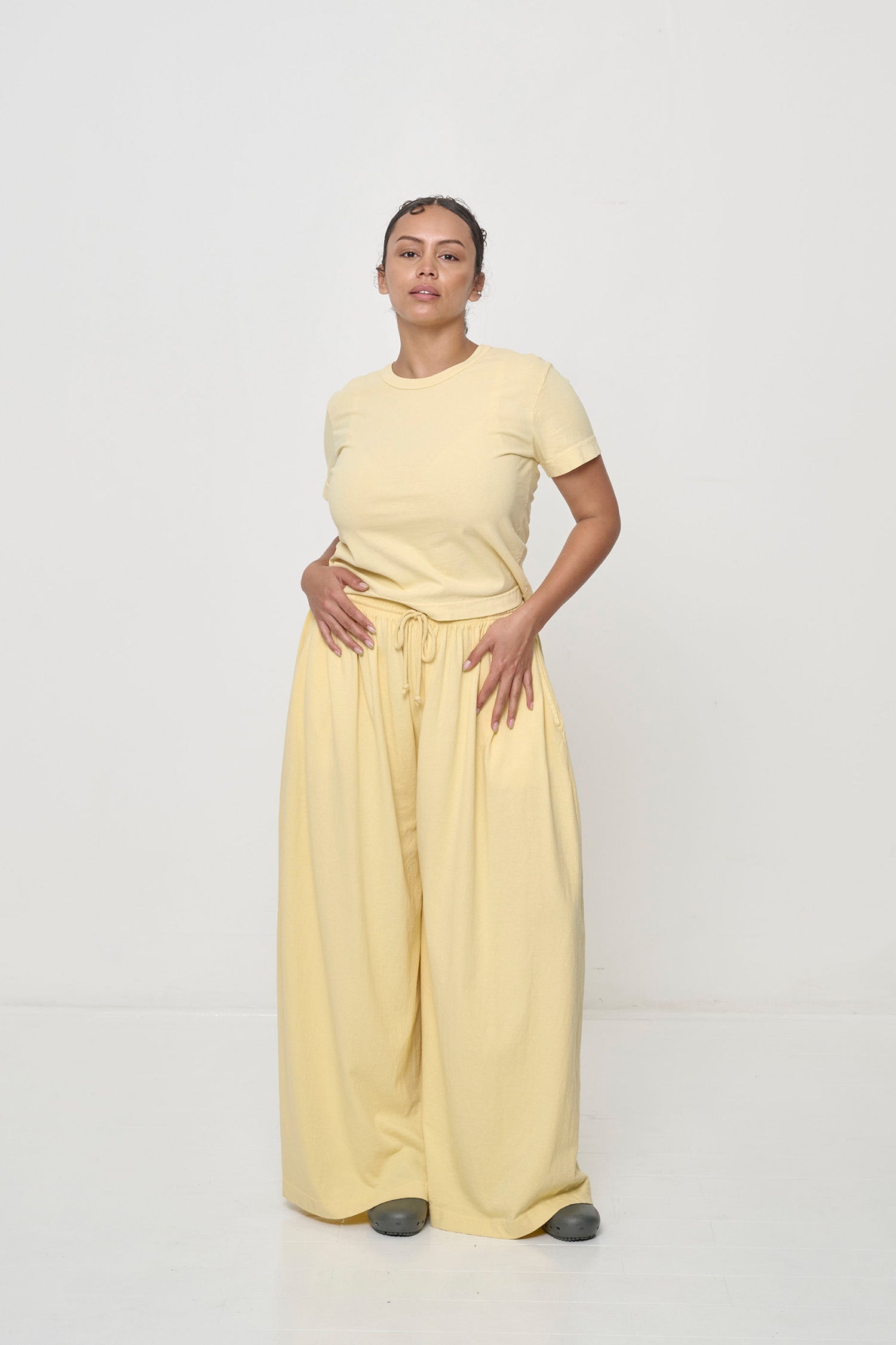 Woman with hip and knee popped, showing the width and movement of the French Butter Tubular Pants.