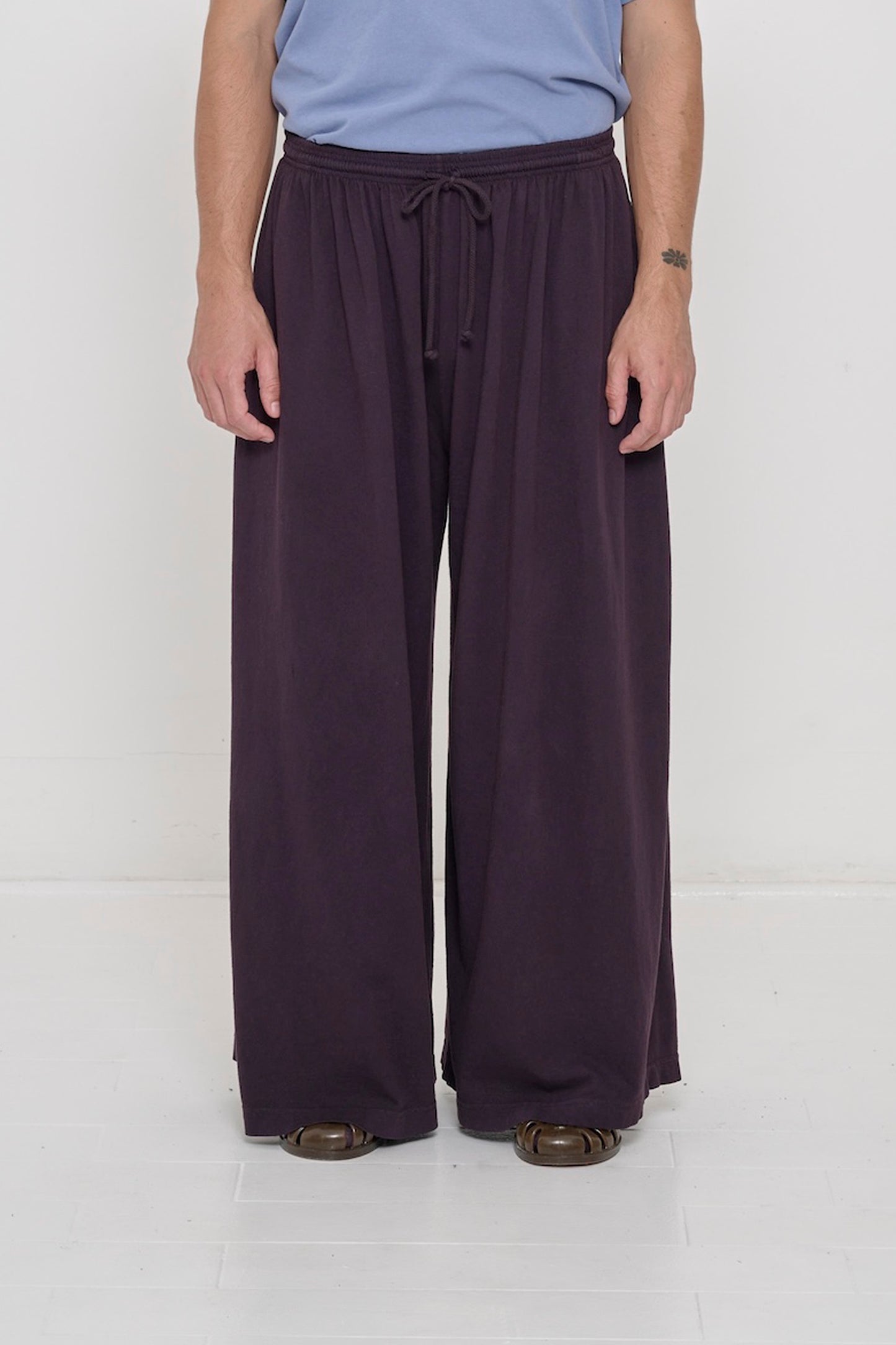 Front view of a person in Mulberry Tubular Pants, featuring elastic waistband, drawcord, relaxed drape.