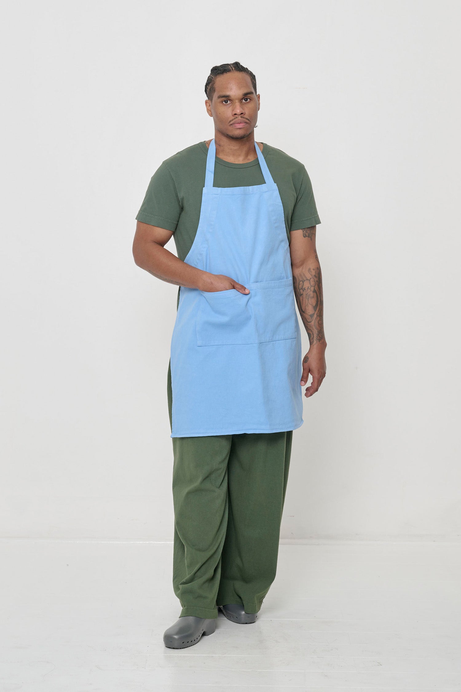 Man in matching Pine Tubular Pants and tee, topped with Cielo blue Apron.