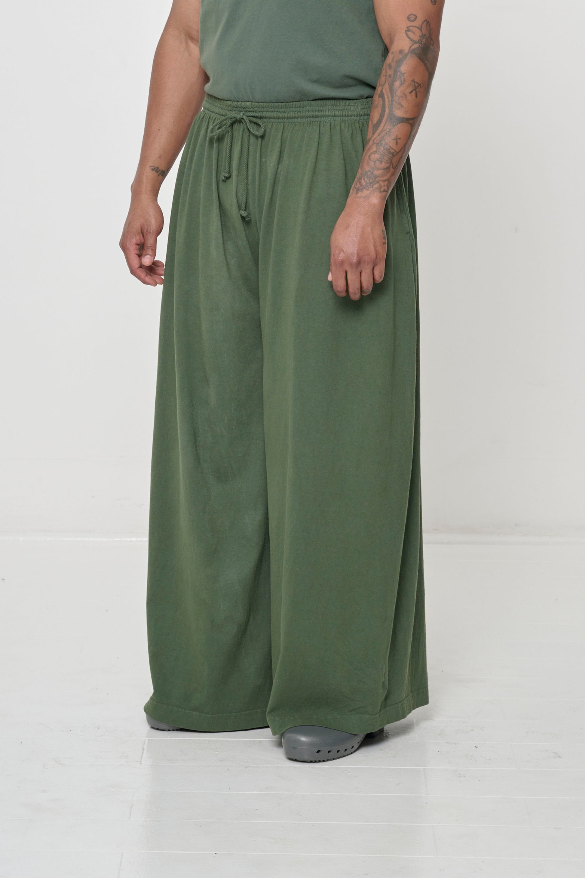 Person facing 45-degrees to the front in Pine Tubular Pants, showing lack of side seams and flowing wide pant legs.