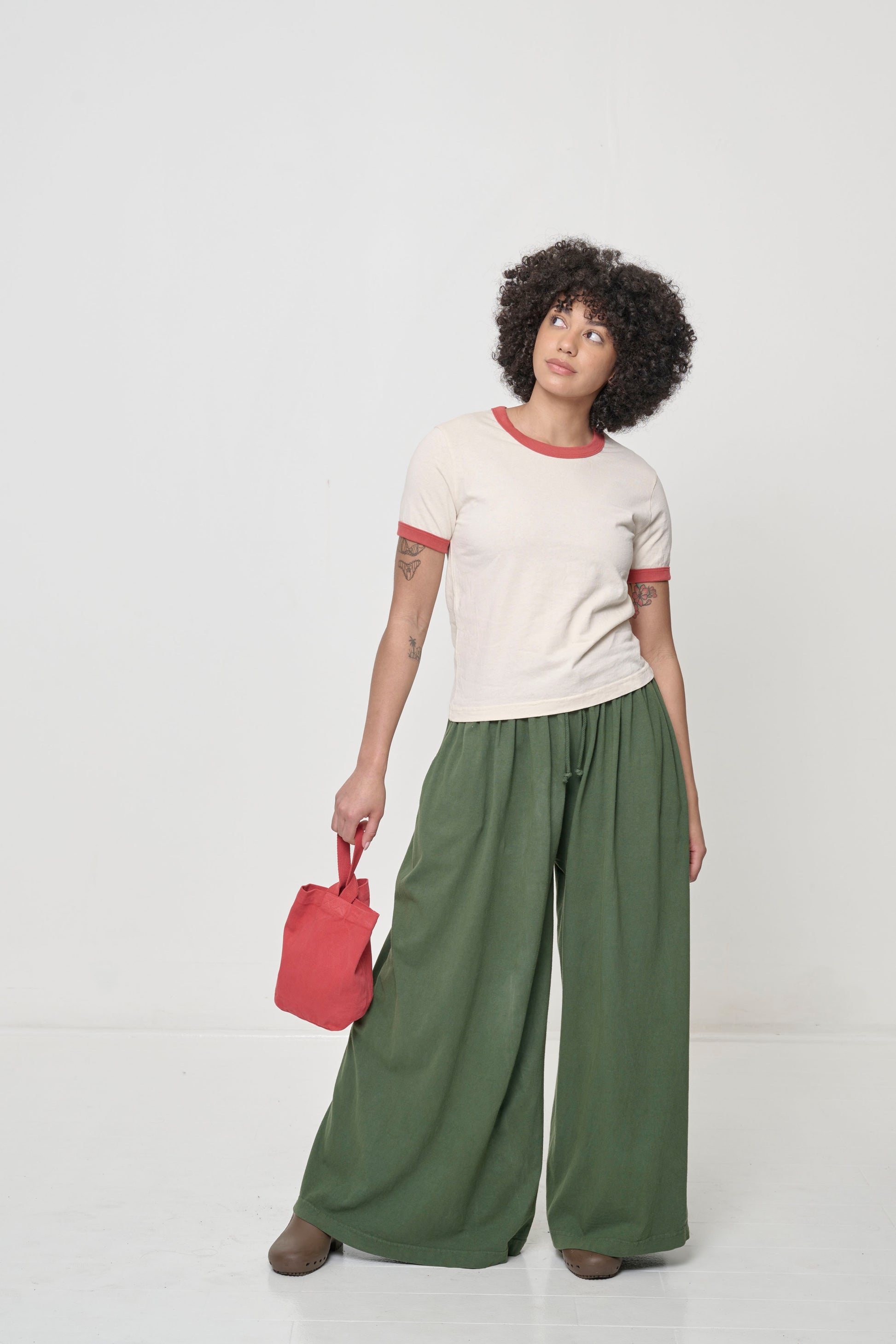 Woman in Pine Tubular Pants, feet wider than hip width to allow width of pant legs to flow.