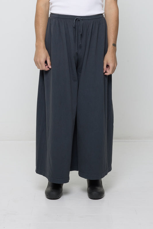 Front view: person in Slate Tubular Pants, featuring elastic waistband, drawcord, relaxed drape.