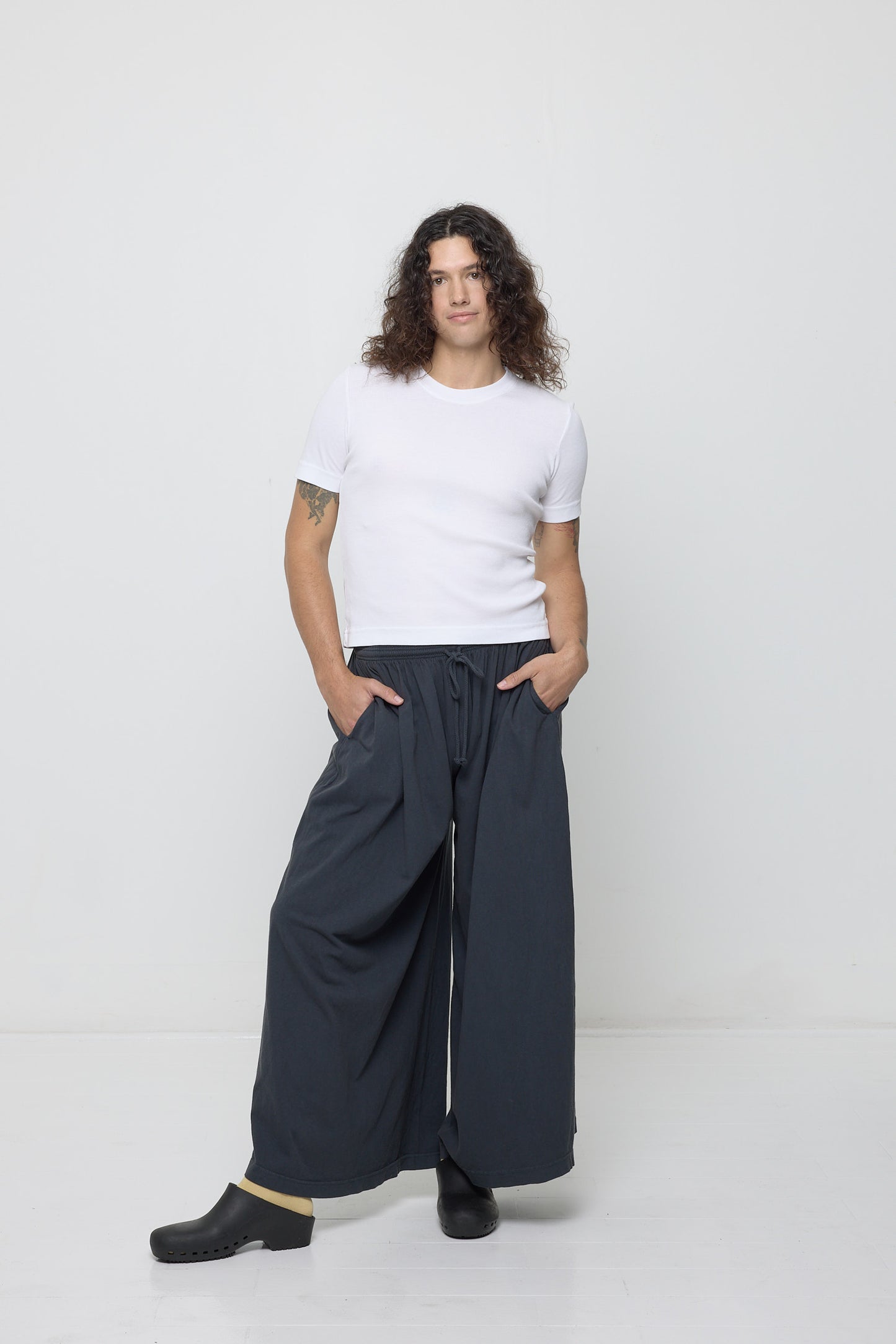 Person in Slate Tubular Pants, with one knee popped, showing the width and movement of the pant legs.