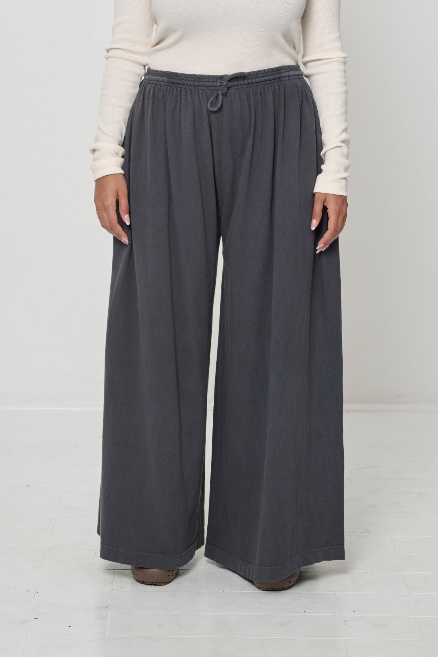 Front view: person in Slate Tubular Pants, featuring elastic waistband, drawcord, relaxed drape.