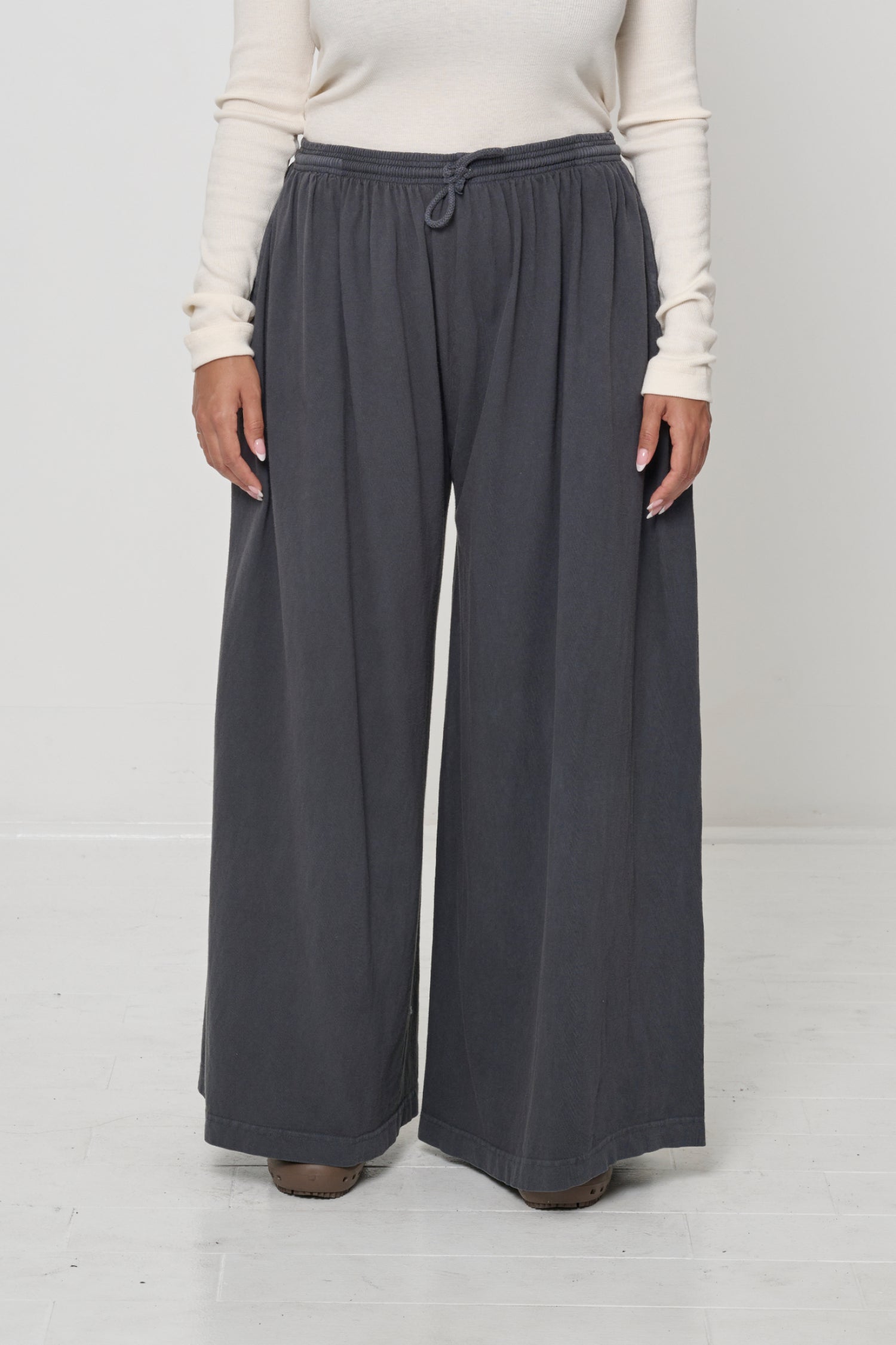 Front view: person in Slate Tubular Pants, featuring elastic waistband, drawcord, relaxed drape.