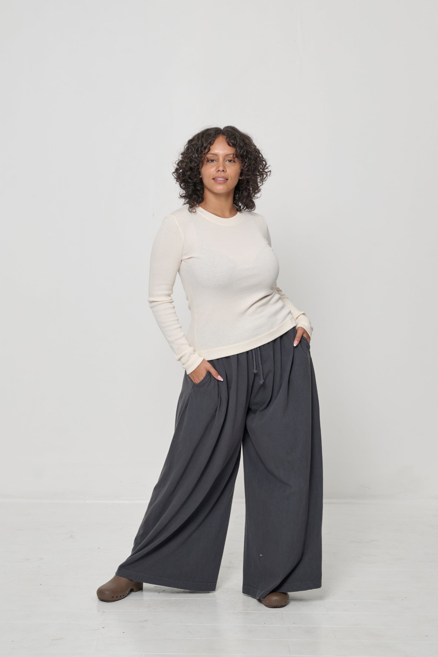 Woman in Tubular Pants in Slate, feet wider than hip width to allow width of pant legs to flow.