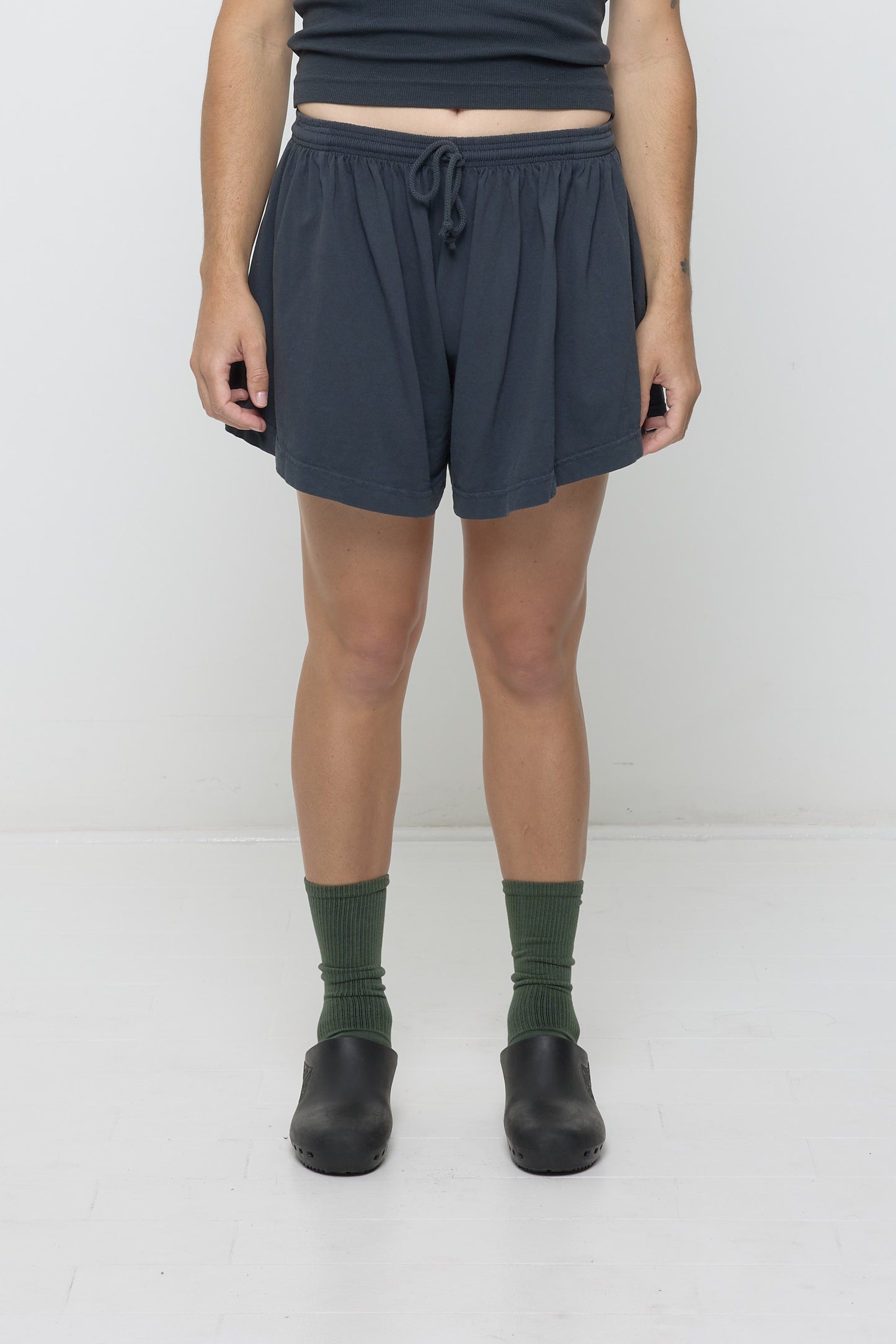 Front view: 6' person in Slate Tubular Shorts. Front hem hits upper mid thigh, and gets shorter at the sides.