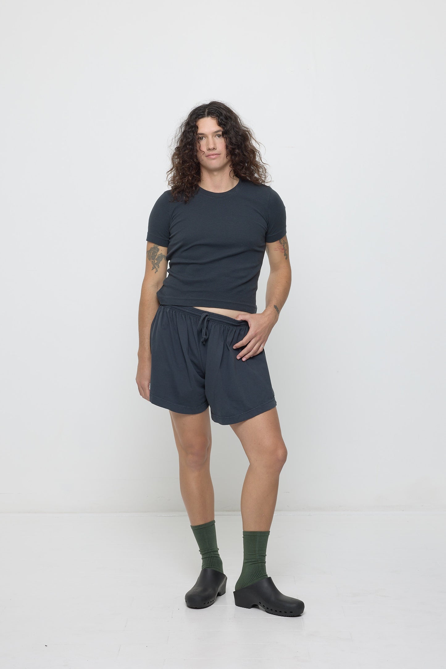 Person in matching Slate Rib Short Sleeve and Tubular Shorts with one thumb tucked into waistband.