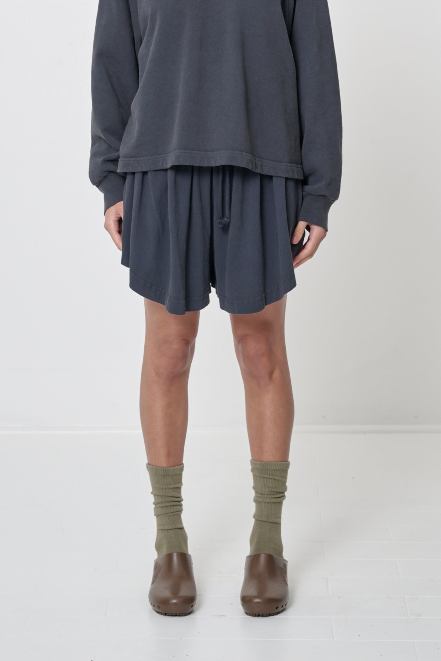 Front view: 5'8" person in Slate Tubular Shorts. Front hem hits mid thigh and gets shorter at the sides.