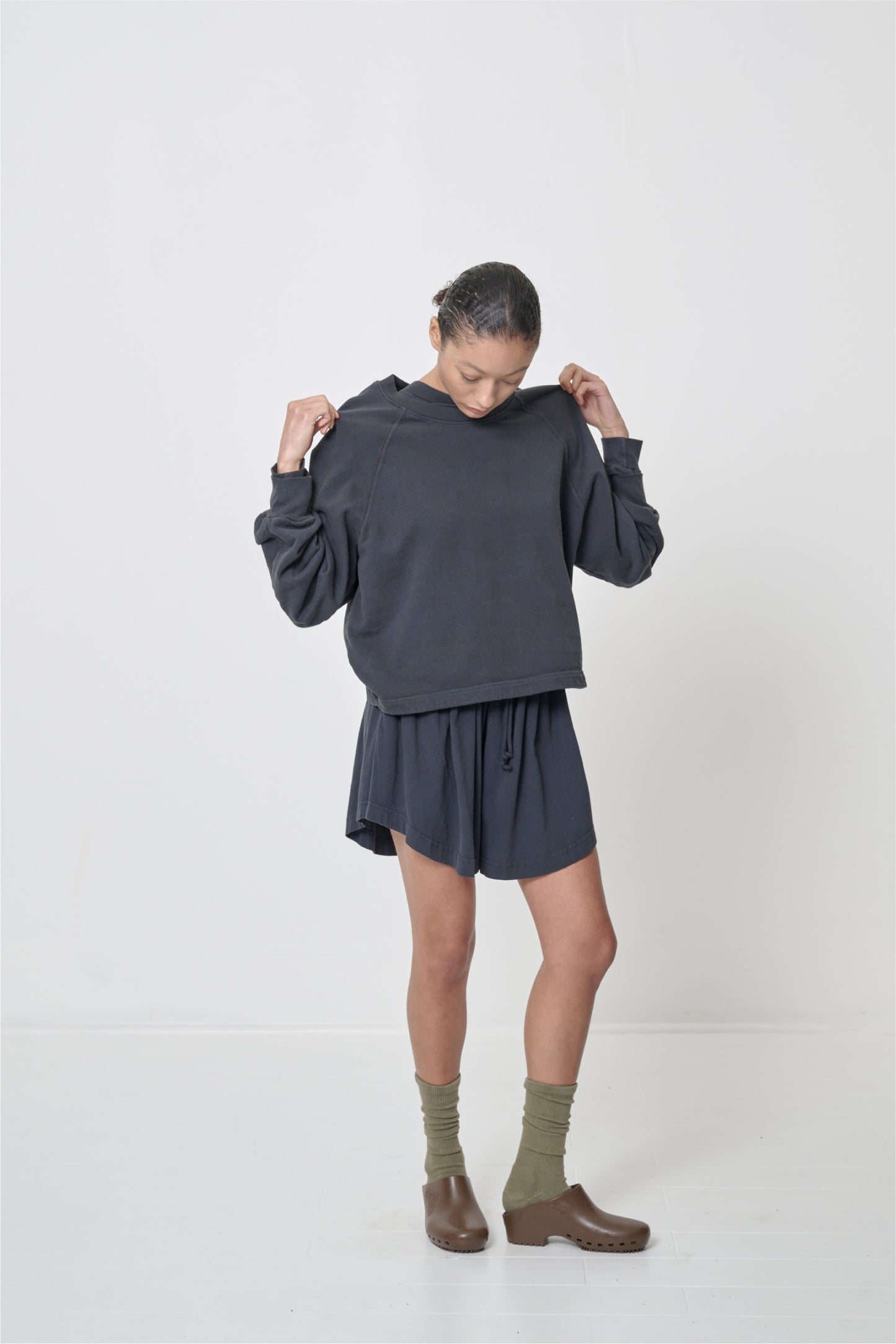 Person facing 45-degrees to the front in matching Slate Trash Raglan and Tubular Shorts, highlighting the shorter side hem.