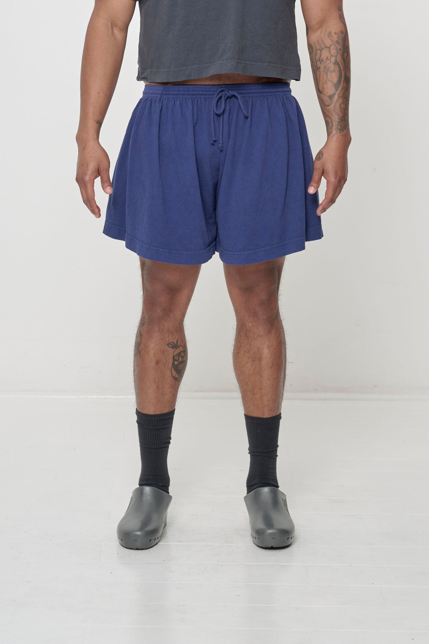 Front view: 6' person in Washed Navy Tubular Shorts. Front hem hits mid thigh and gets shorter at the sides.