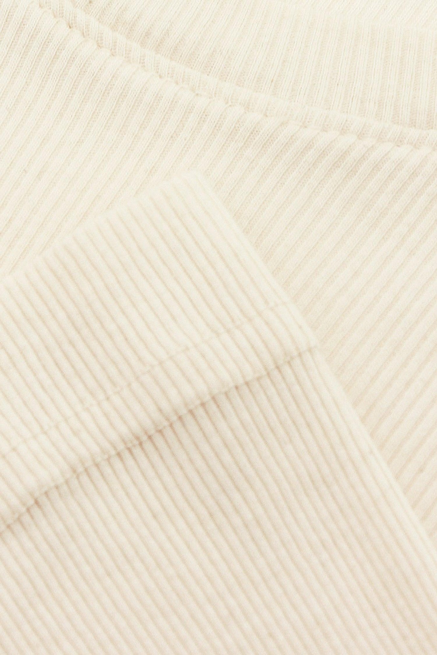 Close-up flat lay showing fine knit stitches and hems seams.