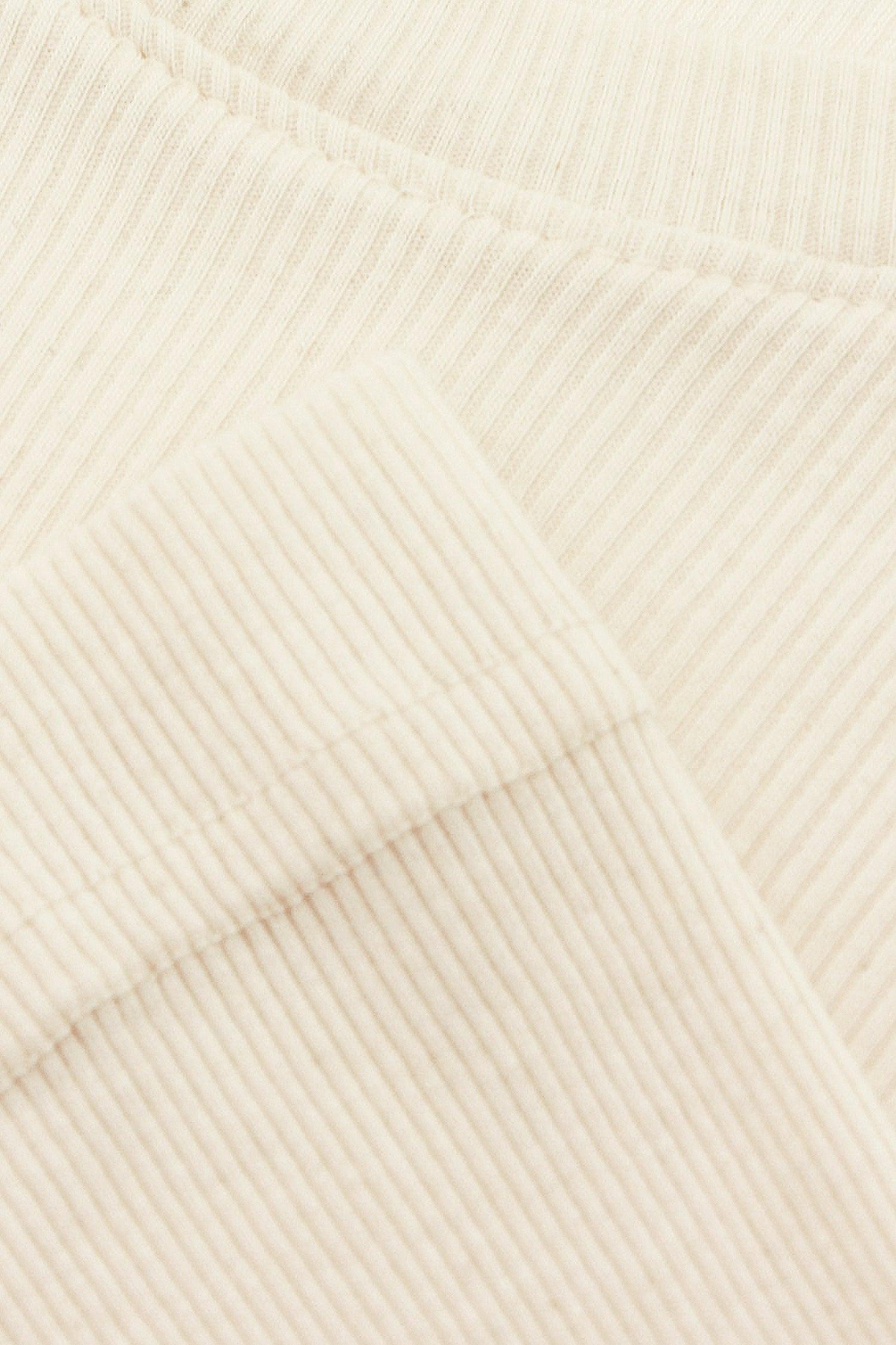 Close-up flat lay showing fine knit stitches and hems seams.
