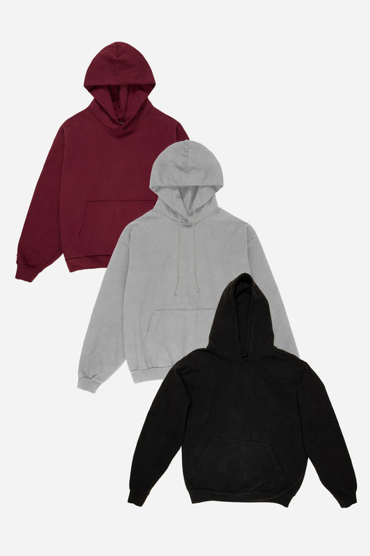 Flat lay of three hoodies in Burgundy, Grey, and Black on a white background