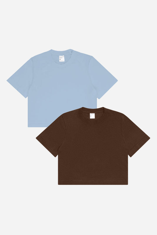 Flat lay of Soil and Fog (light blue) baby tees