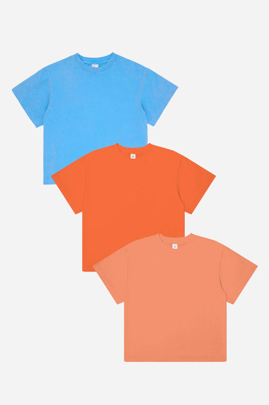 Three t-shirts in blue, orange, and peach on a white background