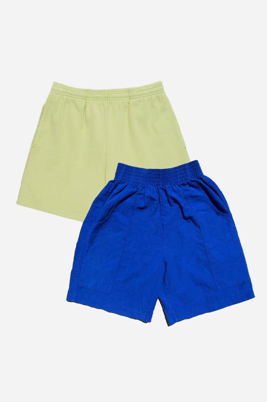 Two pairs of shorts, one green and one blue, on a white background